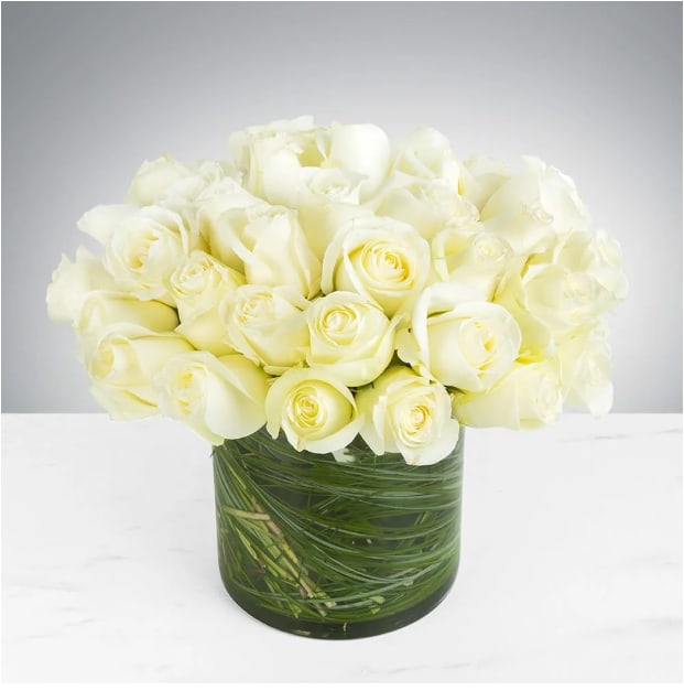 Two Dozen White Roses by BloomNation™ Two Dozen White Roses by BloomNation™ - Make a bold statement with this elegantly simple design. White roses symbolize hope, honor, adoration, and innocence. Two Dozen White Roses by BloomNation⢠is the perfect gift to welcome new beginnings or show your respects. Arrangement Details: Three dozen red roses in a glass cylinder vase. APPROXIMATE DIMENSIONS are 11"D X 12"H