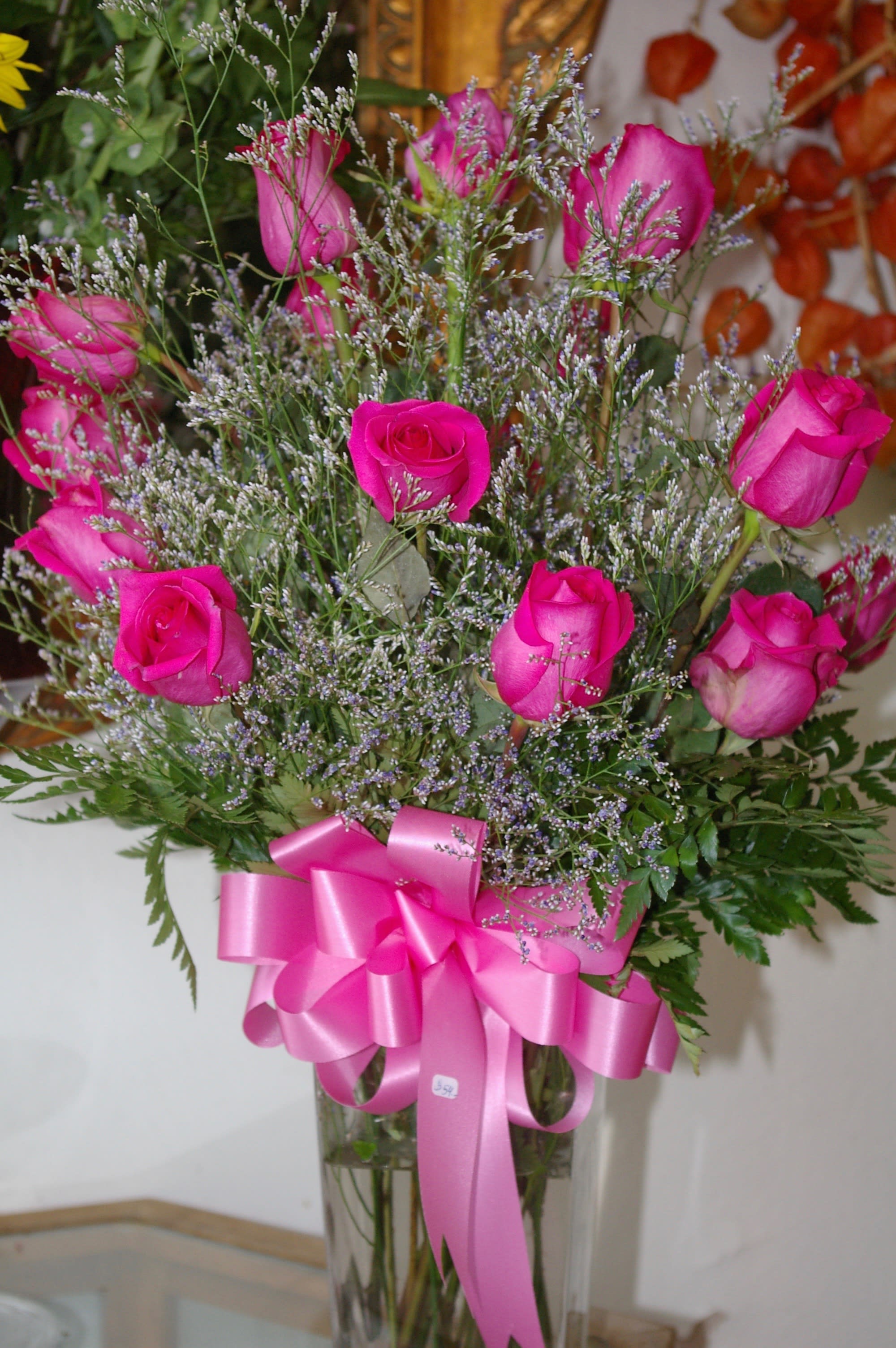love in hot pink - Dozen Hot pink roses with misty blues in a vase.