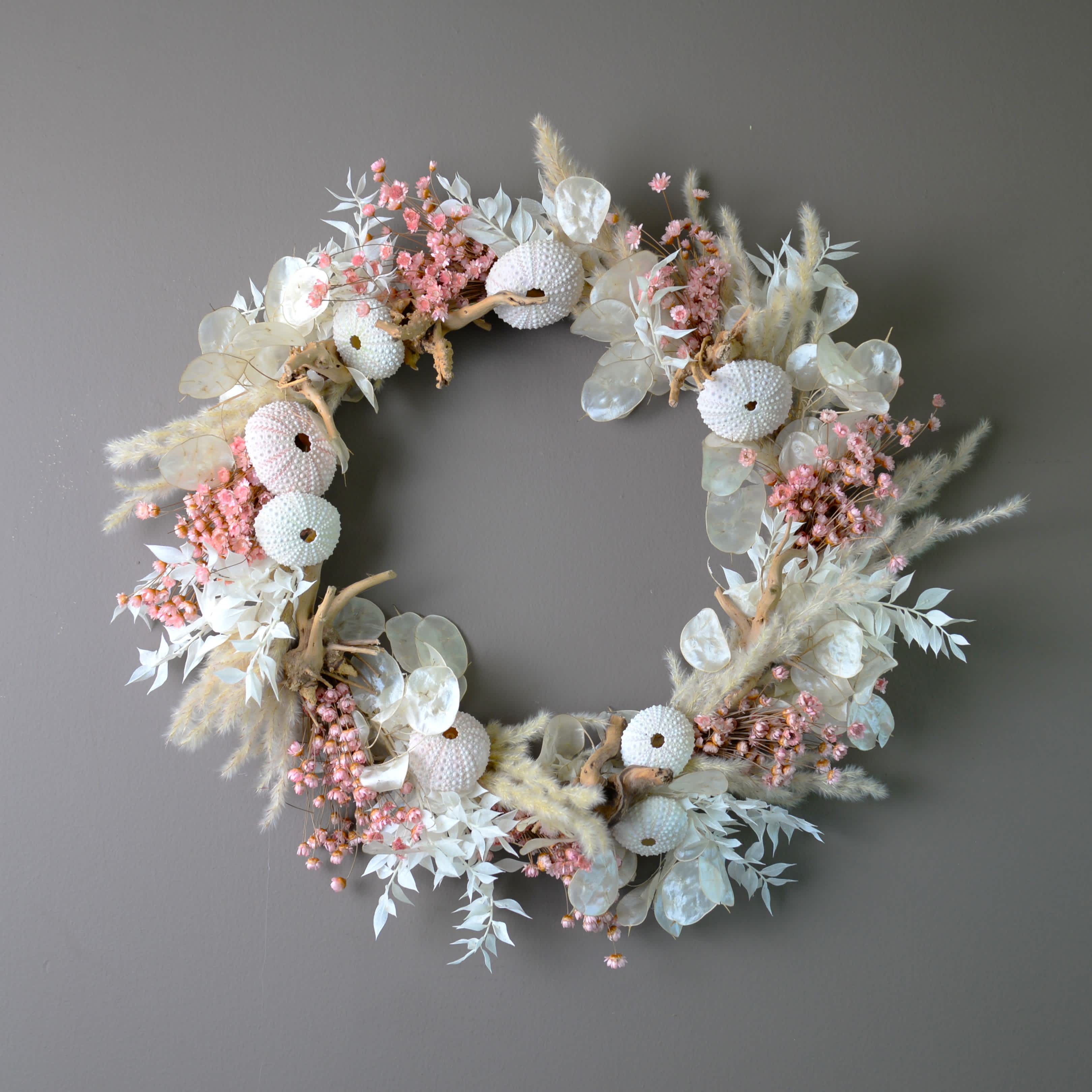 Catalina Island - A modern dried wreath in off white, blush pink and earth tones.  Sea shells and drift wood pieces give this wreath a maritime feel. Finished size is approximately 15&quot;.