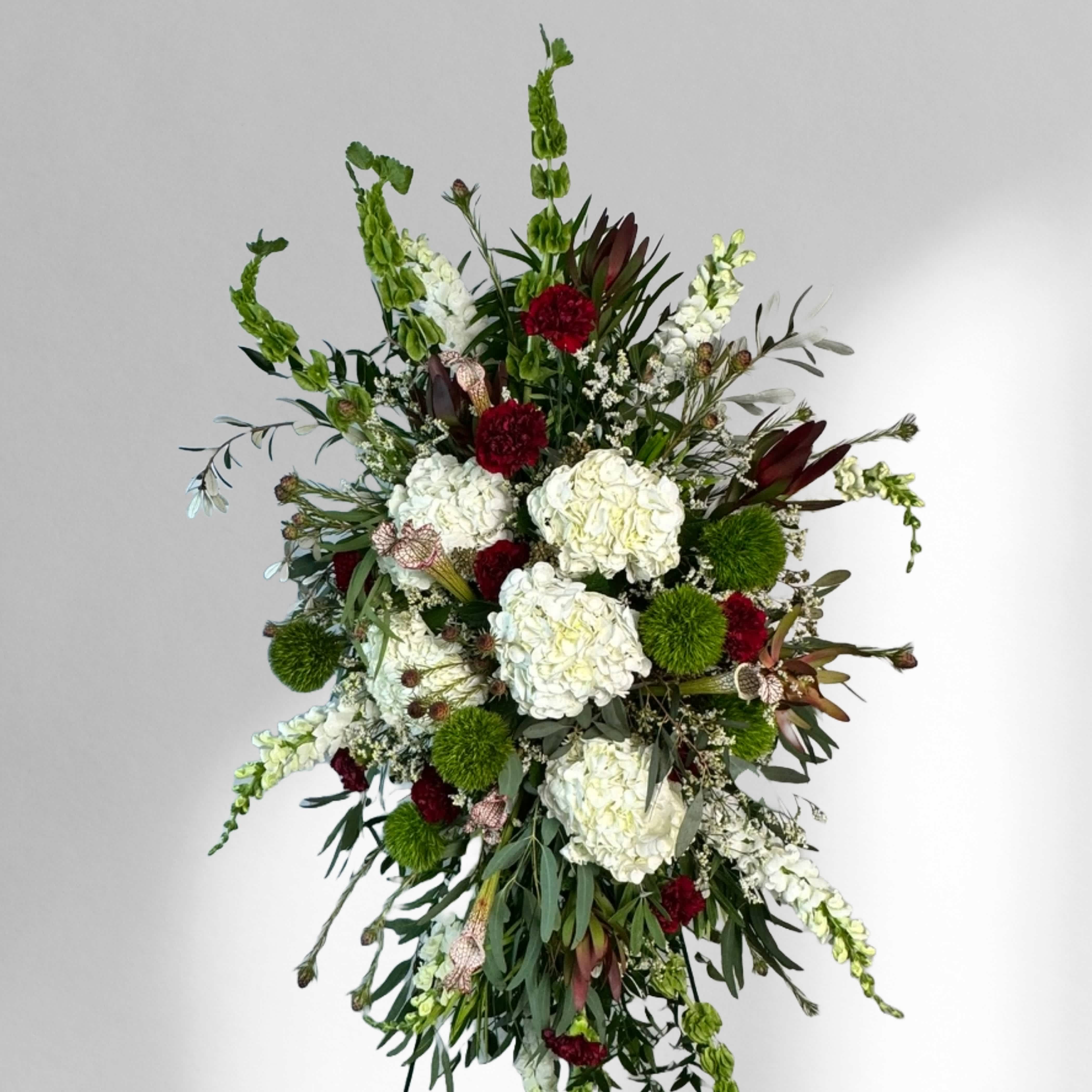 Magnificent Life Spray - This luscious standing spray speaks of a life well lived. Rich colors are set against hydrangeas and a variety of textures of greenery.   This piece can be customized with most colors. 