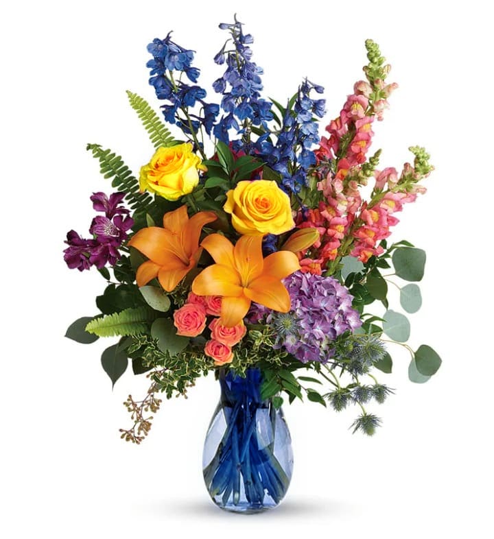 Brighten the Day - Big, Beautiful, and Bright this arrangement makes a big statement. Filled with lilies, roses, spray roses, hydrangea, alstromeria, delph, snaps, thistle, and mixed greens