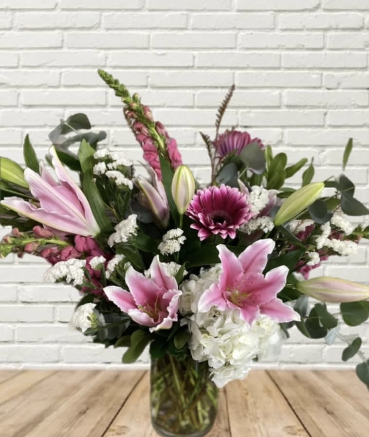 Posey Peddler Posey Peddler - A stunning baby pink and white combination with show stoppers including lilies, hydrangeas, etc.