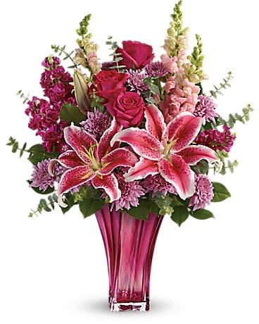 Teleflora's Bold Elegance Bouquet - When only the best will do for Mother's Day, surprise her with this incredible gift! Large and lush, this bouquet of hot pink roses, pink stargazer lilies and lavender mums is fragrant, feminine and fabulous. What an unforgettable treat when hand-delivered in this exquisite blown glass vase! This elegant bouquet features hot pink roses, pink stargazer lilies, burgundy stock, lavender cushion spray chrysanthemums, pink snapdragons, spiral eucalyptus, and lemon leaf. Delivered in a Bold Elegance vase.