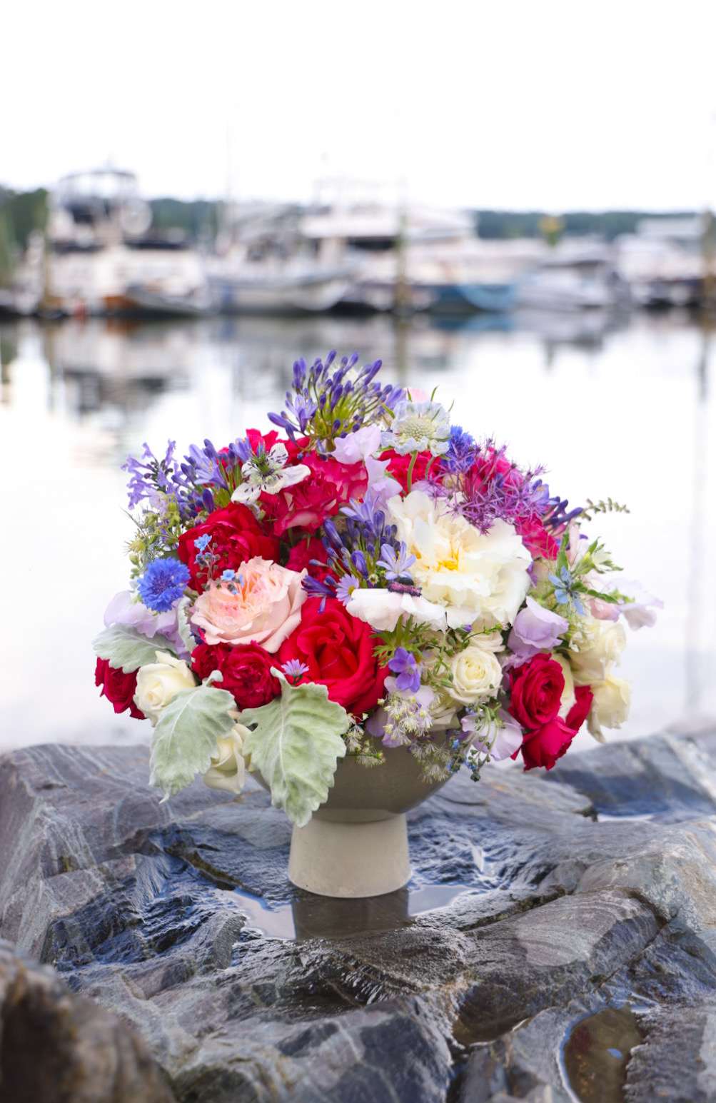 The Star Spangled Arrangement - Fireworks, family, lightning bugs, salt water or fresh and a good dash of sunshine. Wherever you celebrate Independence Day, make the day interdependent with all you love and elevated  with our Star Spangled Floral Arrangement. Summery fresh, sparkling and bright. Oh say can you see this gorgeous arrangement in crimson, cornflower and shimmery white on your holiday table? Order today!  Custom, one of a kind floral arrangements by floral artist Stacy Leafsong.  Photos provide examples, and each arrangement &amp; vase is unique.  Arrangements will be delivered before 7pm, for specific delivery time please include in special instructions. On holidays, our busiest times, deliveries will be made by 7:30pm.