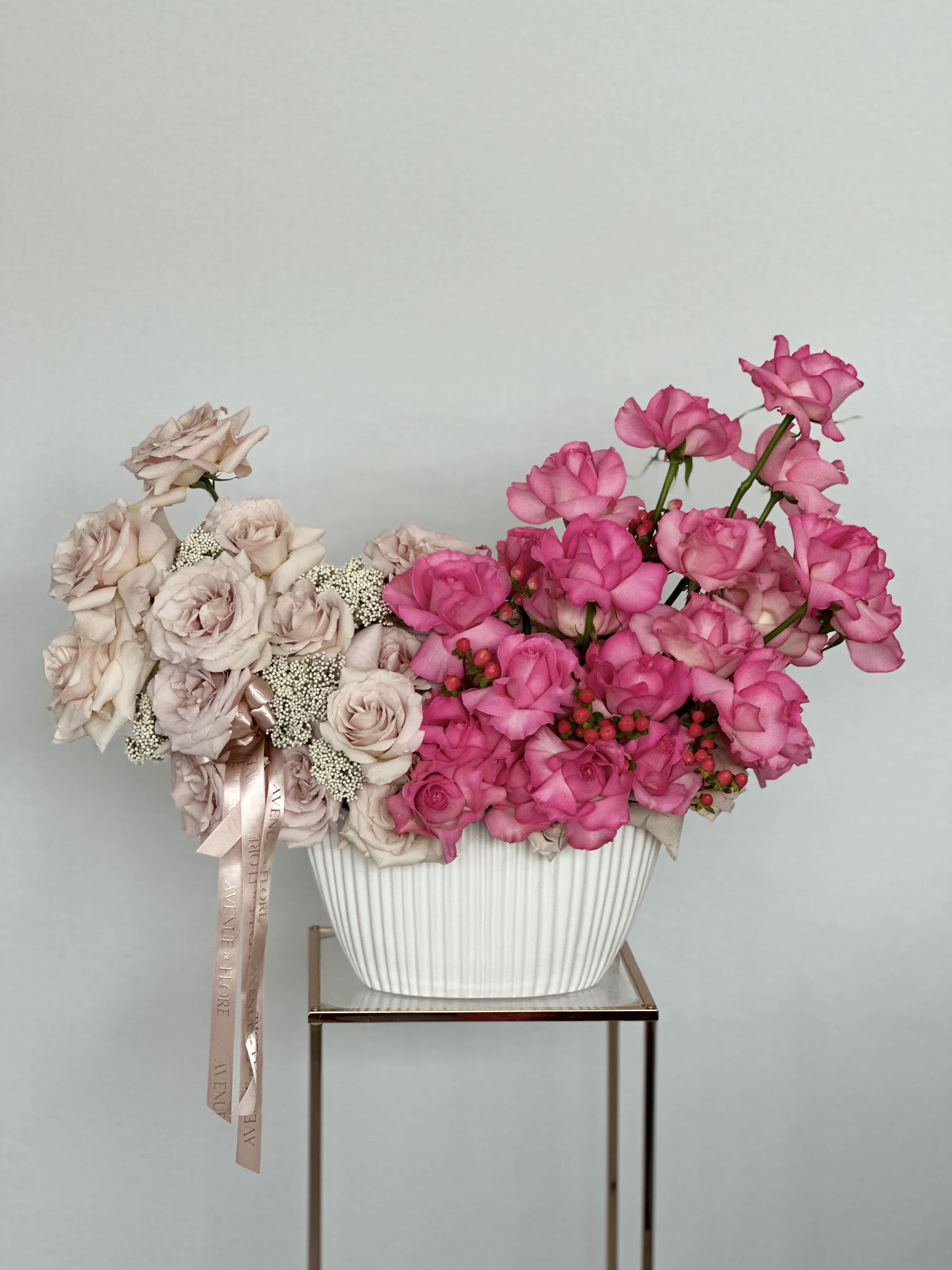 Dual Beauty - A chic vase adorned with an elegant arrangement of pink and sand-colored roses. The sleek vase complements the soft colors of the roses, enhancing their natural beauty and instantly brightening any room. 