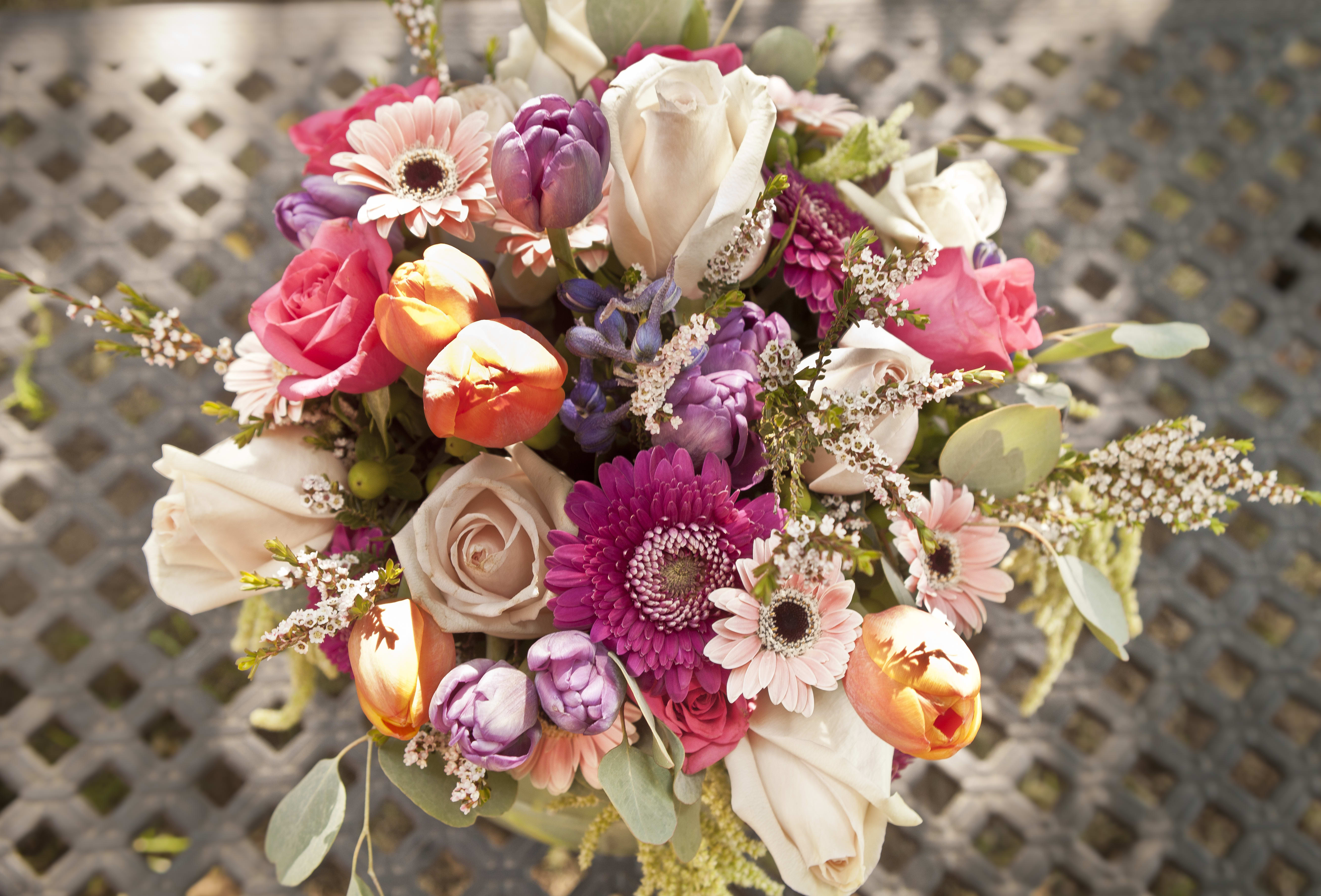 Rustico - Indulge in the beauty of this stunning pedestal vase filled with dusty pink roses, vibrant daisies, purple tulips, stock, and other beautiful flowers. Perfect for adding elegance and charm to any occasion. Order now to bring this exquisite arrangement into your home or to delight someone special!