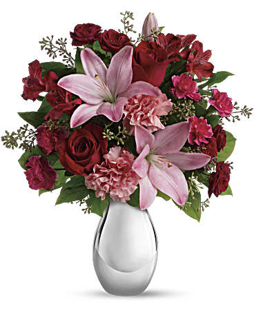 Teleflora's Moonlight Kiss Bouquet - She'll feel the love when she receives this gorgeous array of roses, lilies and more artistically arranged in a dazzling silver reflections vase. You'll also feel the love when she finishes oohing and aahing and turns to thank you. This romantic bouquet includes red roses, red spray roses, pink asiatic lilies, red alstroemeria, pink carnations and pink miniature carnations accented with assorted greenery. Delivered in a silver reflections vase.