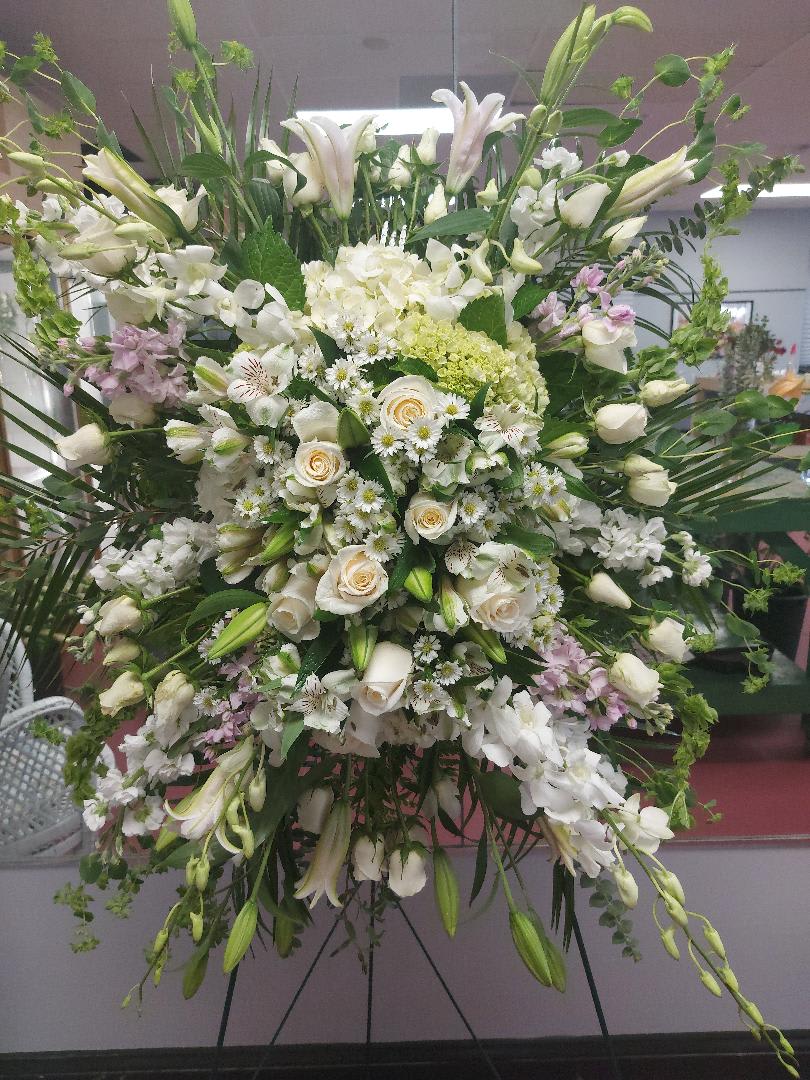 Hanging Spray - Exquisitely designed mostly white casket cover featuring our top quality orchids, roses, hydrangeas, lilies, bells of Ireland and assorted greenery.