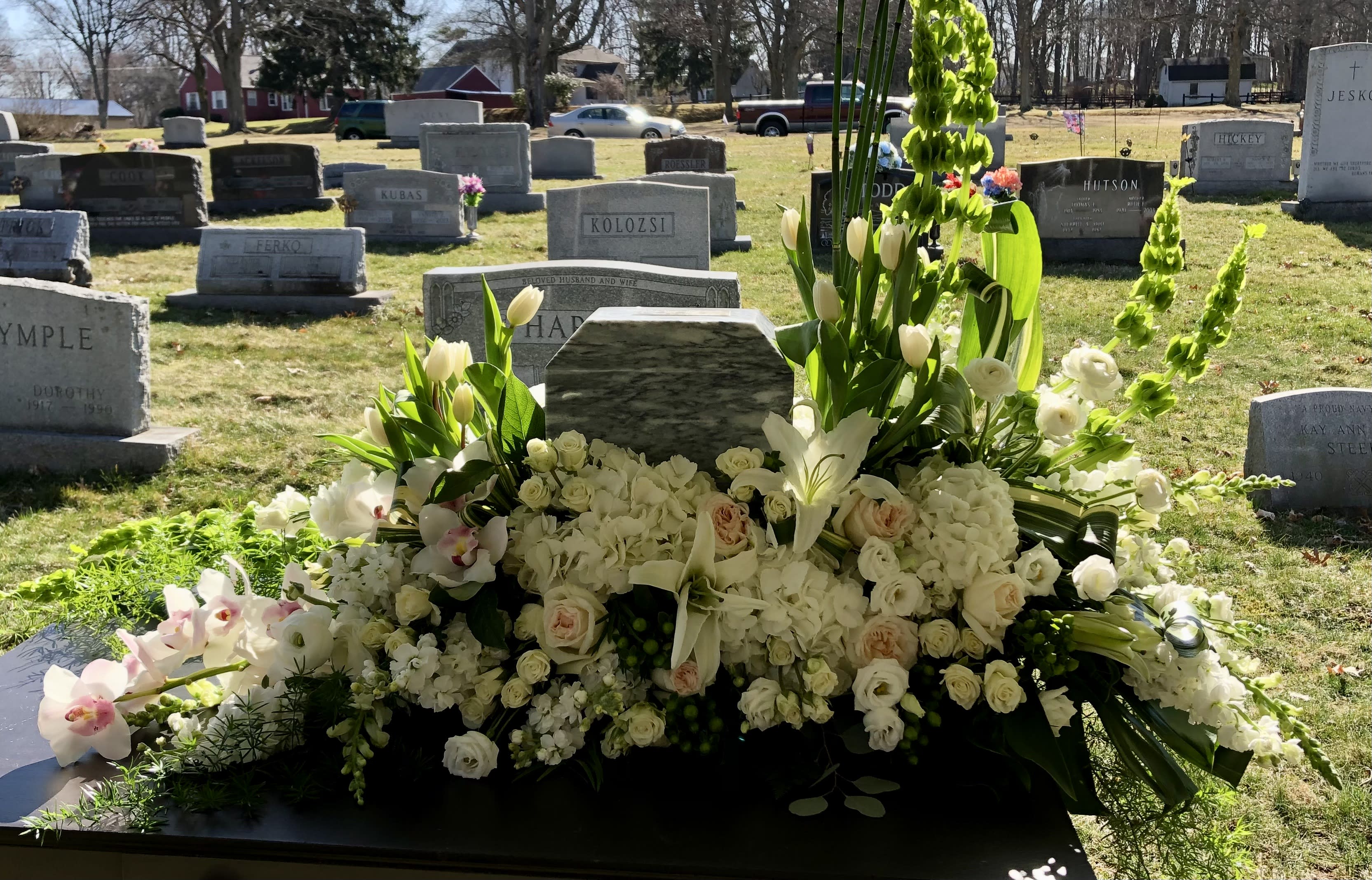 All ways in my heart - Call for pricing.  White, green, blush florals in an elegant tribute to a loved one. This spray includes orchids, garden roses, spray roses, bells of Ireland. This can be made as an under spray for an Urn or a casket spray. Pricing depends on flowers chosen. As you see it: $850.00 