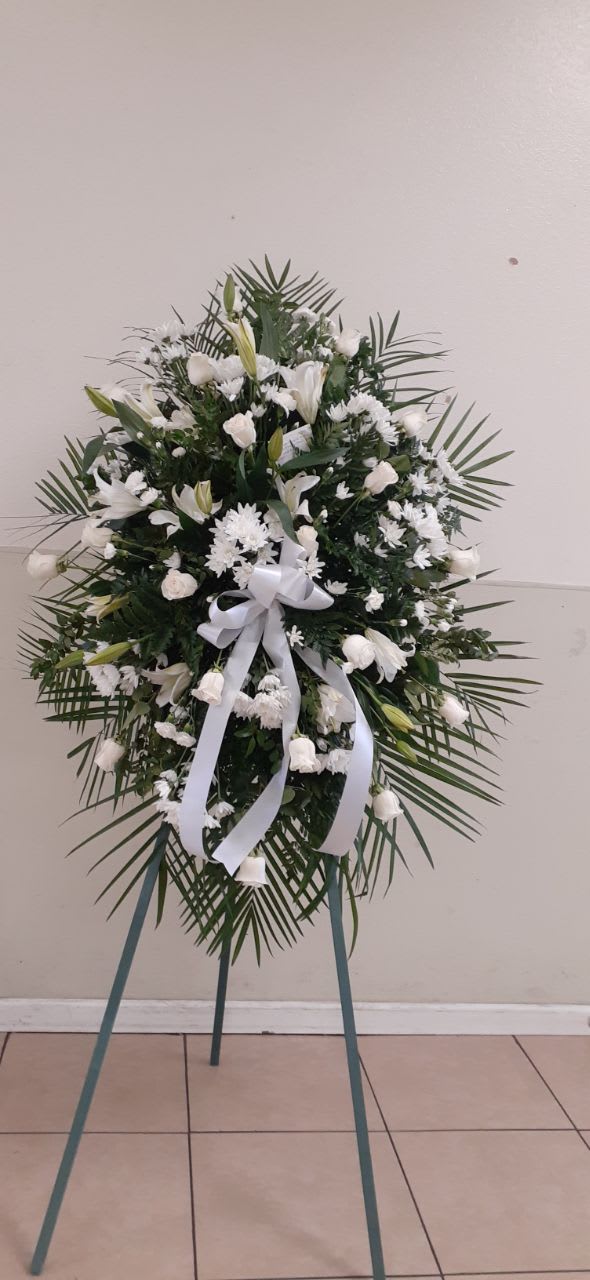 White Standing Spray White Standing Spray - A white standing spray 12 white roses, 3 white stem of lilies, 6 white cushion white, 4 white mini carnation, Robeline leaves, salad tips, white bow and a wood easel.