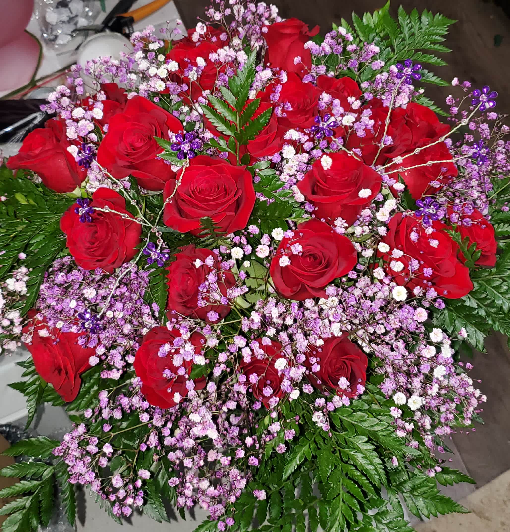 two dozen rose cut bouquet with baby's-breath and greenery - two dozen premium roses ( These are not as long as our premium long stem)  in a cut bouquet with baby's-breath and leather leaf greenery unless otherwise specified.  Bouquet is wrapped and tied with a bow.