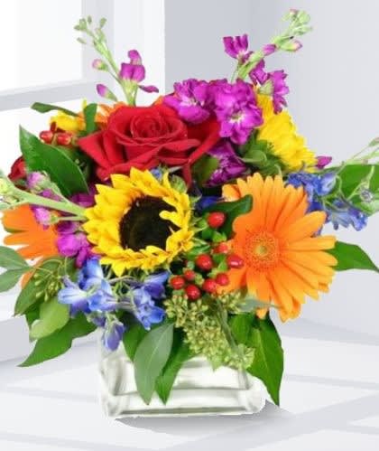 Blossoming Beauty Blossoming Beauty - A bright and vibrant mixture of fresh cut flowers, hand selected to make that someone special in your life smile. Great for Birthdays, thank you, or just because! Arrangements Shown Reflects Deluxe Pricing.