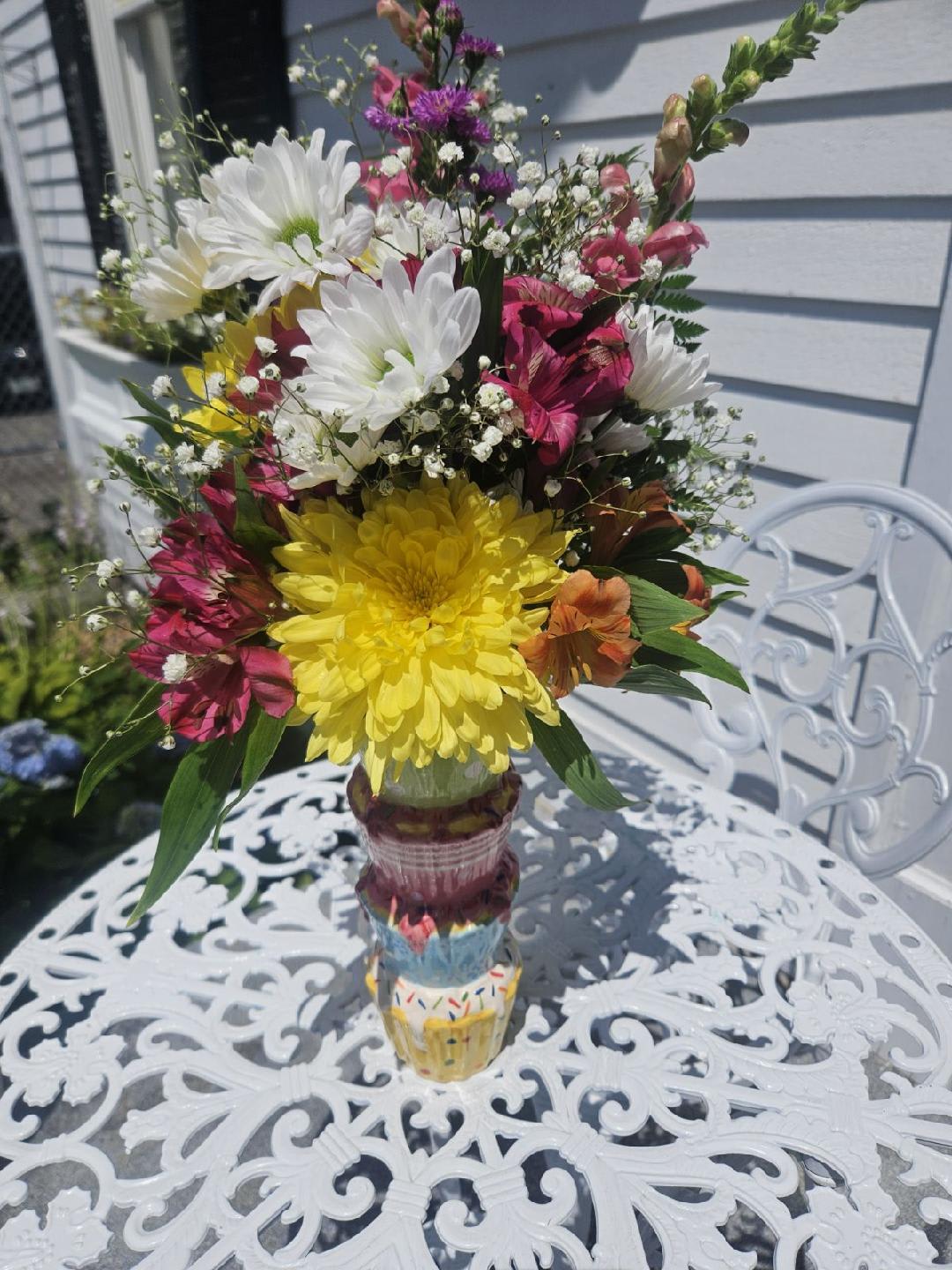 New Cupcake Arrangement New Cupcake Arrangement - Ceramic Tired cup cake vase filled with Pinks, yellows, purples whites and orange flowers