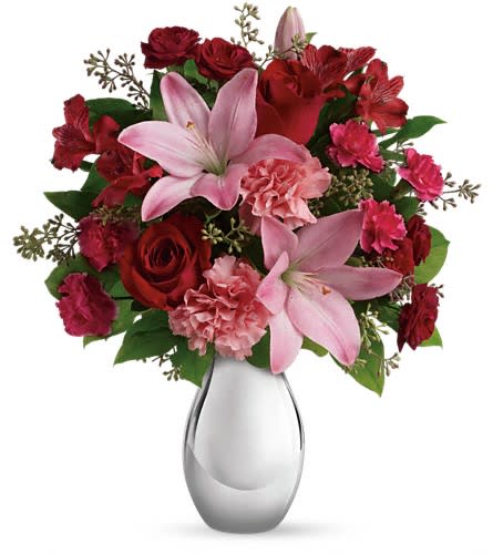 Teleflora's Moonlight Kiss Bouquet - She'll feel the love when she receives this gorgeous array of roses lilies and more artistically arranged in a dazzling silver reflections vase. You'll also feel the love when she finishes oohing and aahing and turns to thank you. This romantic bouquet includes red roses red spray roses pink asiatic lilies red alstroemeria pink carnations and pink miniature carnations accented with assorted greenery. Delivered in a silver reflections vase.Approximately 14 1/2&quot; W x 17 1/2&quot; H Orientation: One-Sided As Shown : T409-1ADeluxe : T409-1BPremium : T409-1C