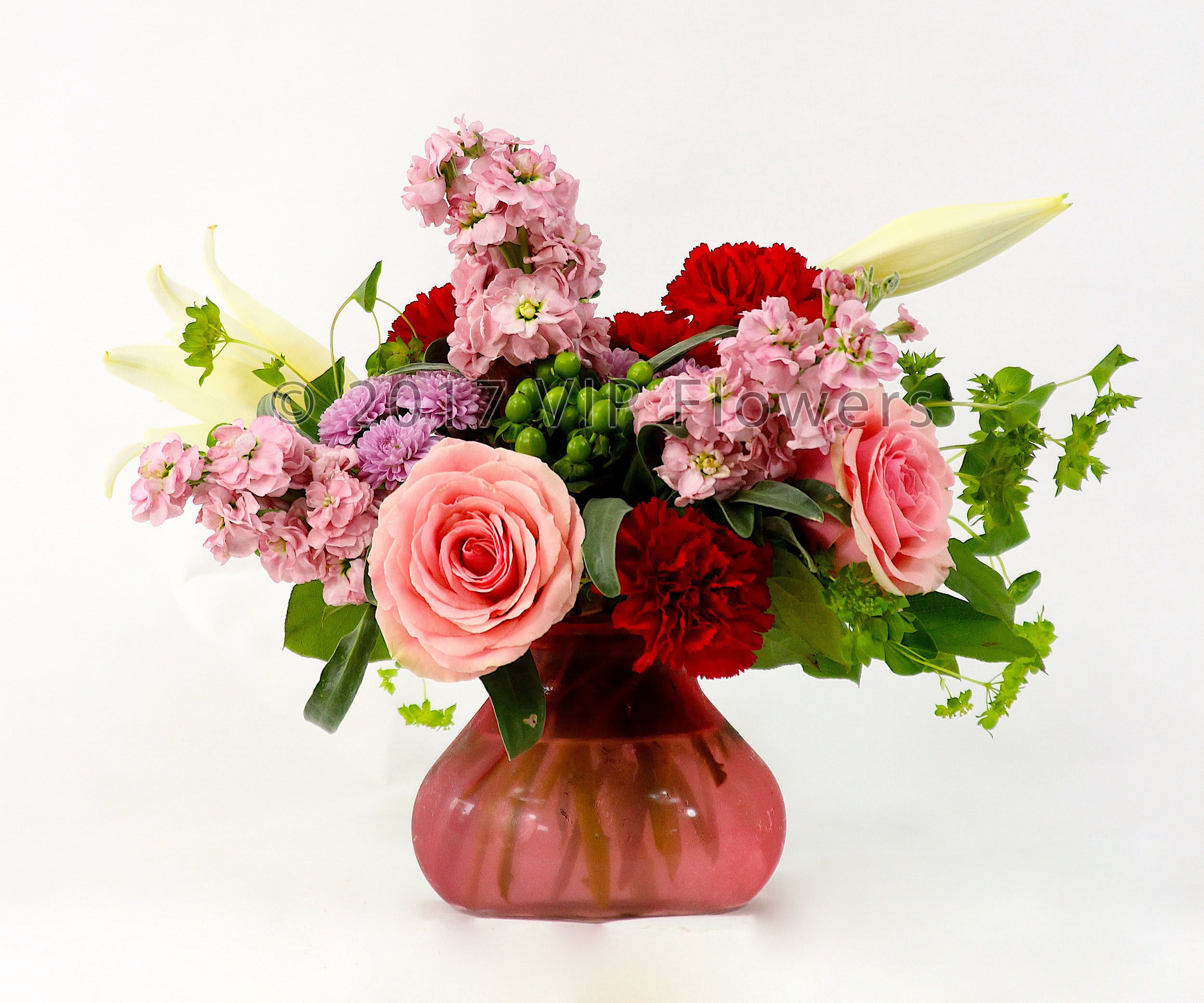 Simply Pink - Flowers Included:  Pink Roses Red Carnations Purple Stock White Lilies Purple Mums Green Berries       Substitutions may be necessary to ensure your arrangement or specialty gift is delivered in a timely manner. The utmost care and attention is given to your order to ensure that it is as similar as possible to the requested item (Please note that some flowers and colors may vary due to seasonality.)