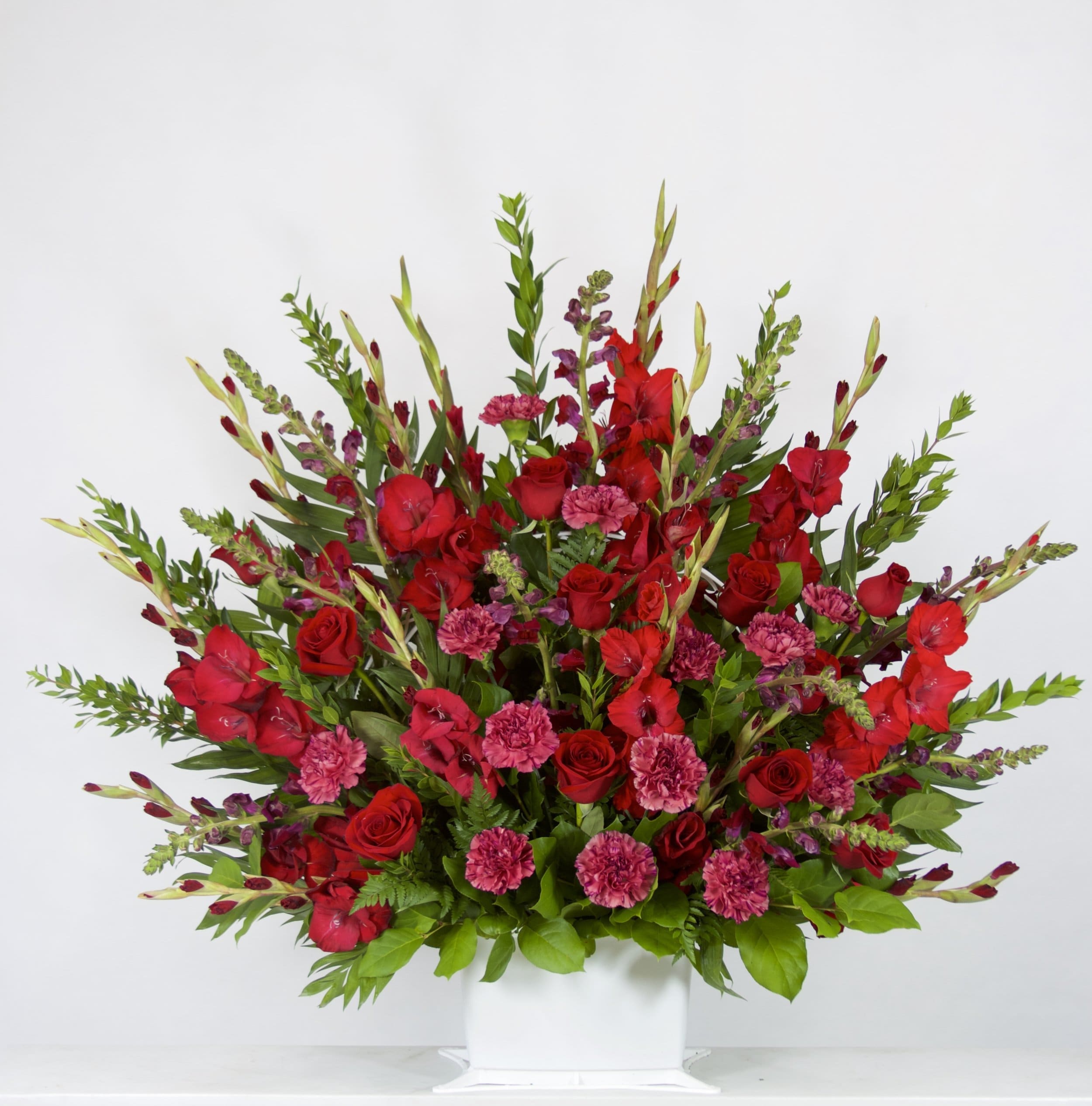 Cardinals Ploy - Flowers Included:  Red Roses Red Carnations Red Gladiolus Seasonal Greens       Substitutions may be necessary to ensure your arrangement or specialty gift is delivered in a timely manner. The utmost care and attention is given to your order to ensure that it is as similar as possible to the requested item (Please note that some flowers and colors may vary due to seasonality.)