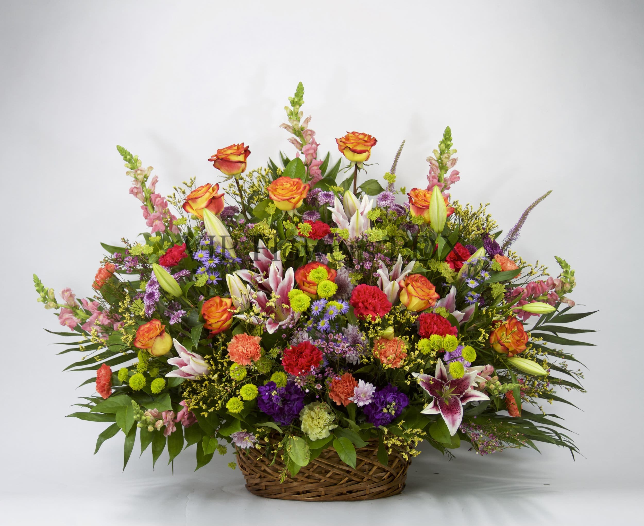Fairyland - Flowers Included:  Red Carnations Orange Roses Pink Snapdragons Stargazer Lilies Purple Mums Green Mums Seasonal Greens       Substitutions may be necessary to ensure your arrangement or specialty gift is delivered in a timely manner. The utmost care and attention is given to your order to ensure that it is as similar as possible to the requested item (Please note that some flowers and colors may vary due to seasonality.)
