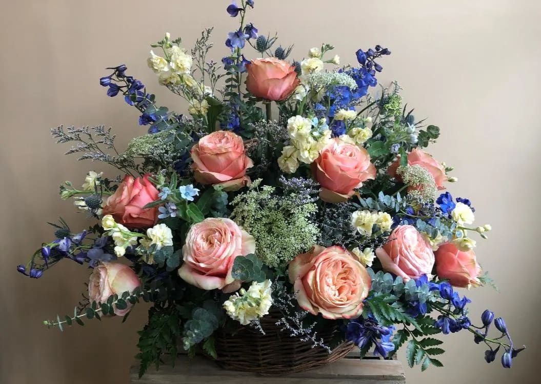 The Hope by Simply Fresh Flowers (72 hour notice required) - The Hope is designed in a premium willow basket incorporating roses, delphinium, stock, queen ann's lace, thistle, alstromeria &amp; accent blooms within a bed of complementary greens. A simply beautiful sentiment of sympathy. Please note: 72 hour notice required)