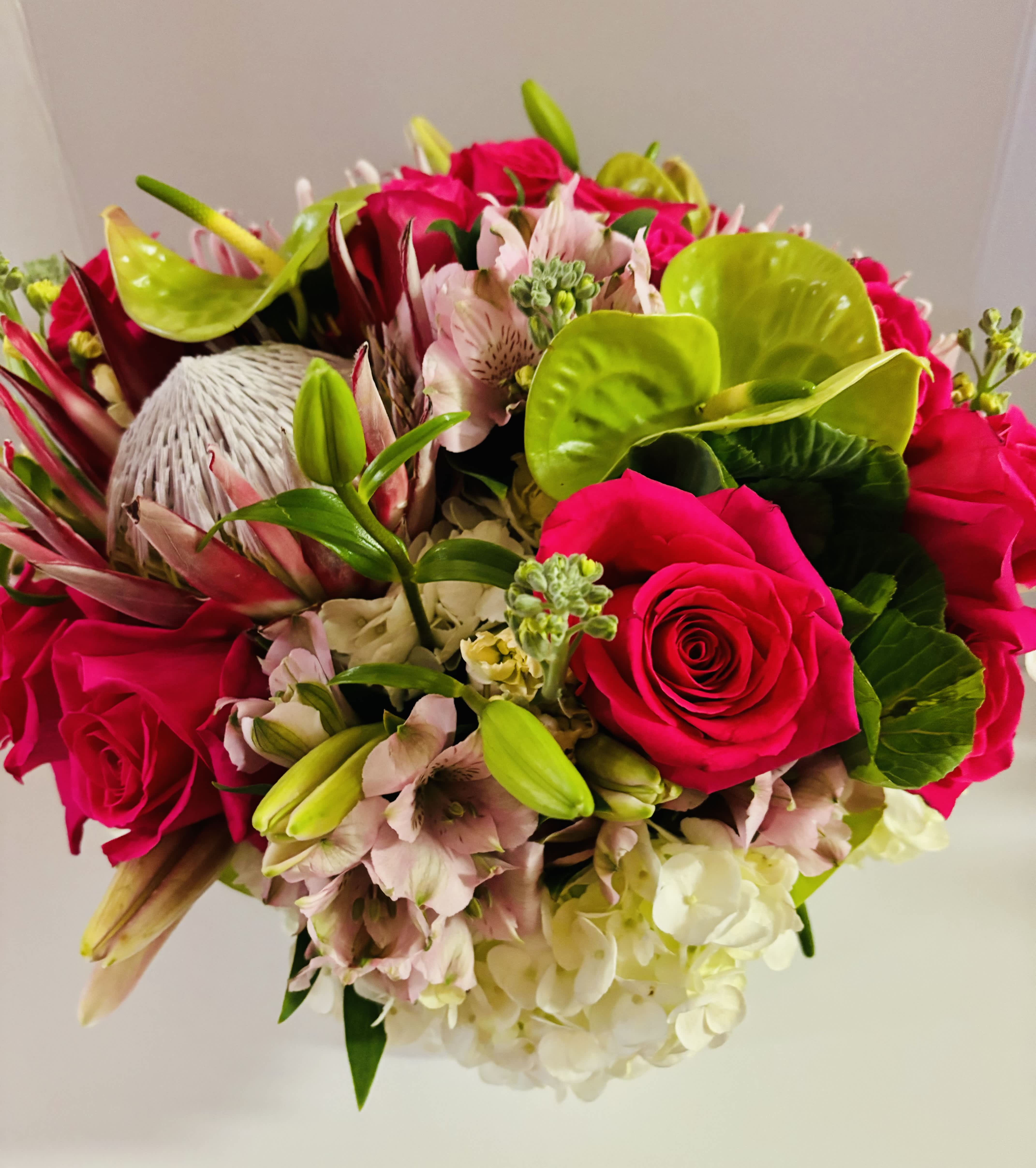 Garden meets tropicals - This bright and cheery arrangment is combination of two tropical blooms and garden blooms (based on availability) designed in a designer's choice container.   Designed to be viewed from all angles.  Enhanced option includes additional blooms and foliage.  All floral arrangments are designed to a style and use seasonal materials of varying content.  Please contact us directly for any custom orders or requests info@helemelebotanicals.com or 808.226.7667  We are committed to malama 'aina and strive to use locally sourced material, reduce packaging and reuse and recycle where possible. We will pick up any of our product (vessels, plants and floral supply material) when delivering a subsequent order. At that time, a $5 credit toward future purchase will be issued for each ceramic, metal or wood vessel returned.