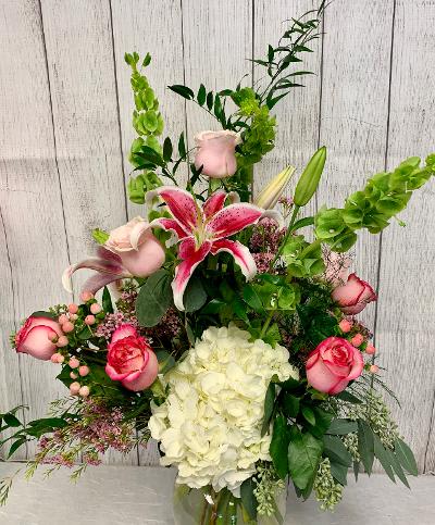 CFE118 CFE118 - A tall showy high end arrangement of pink, green and white flowers such as lilies, roses, hydrangeas, bell of ireland and other beautiful blooms.