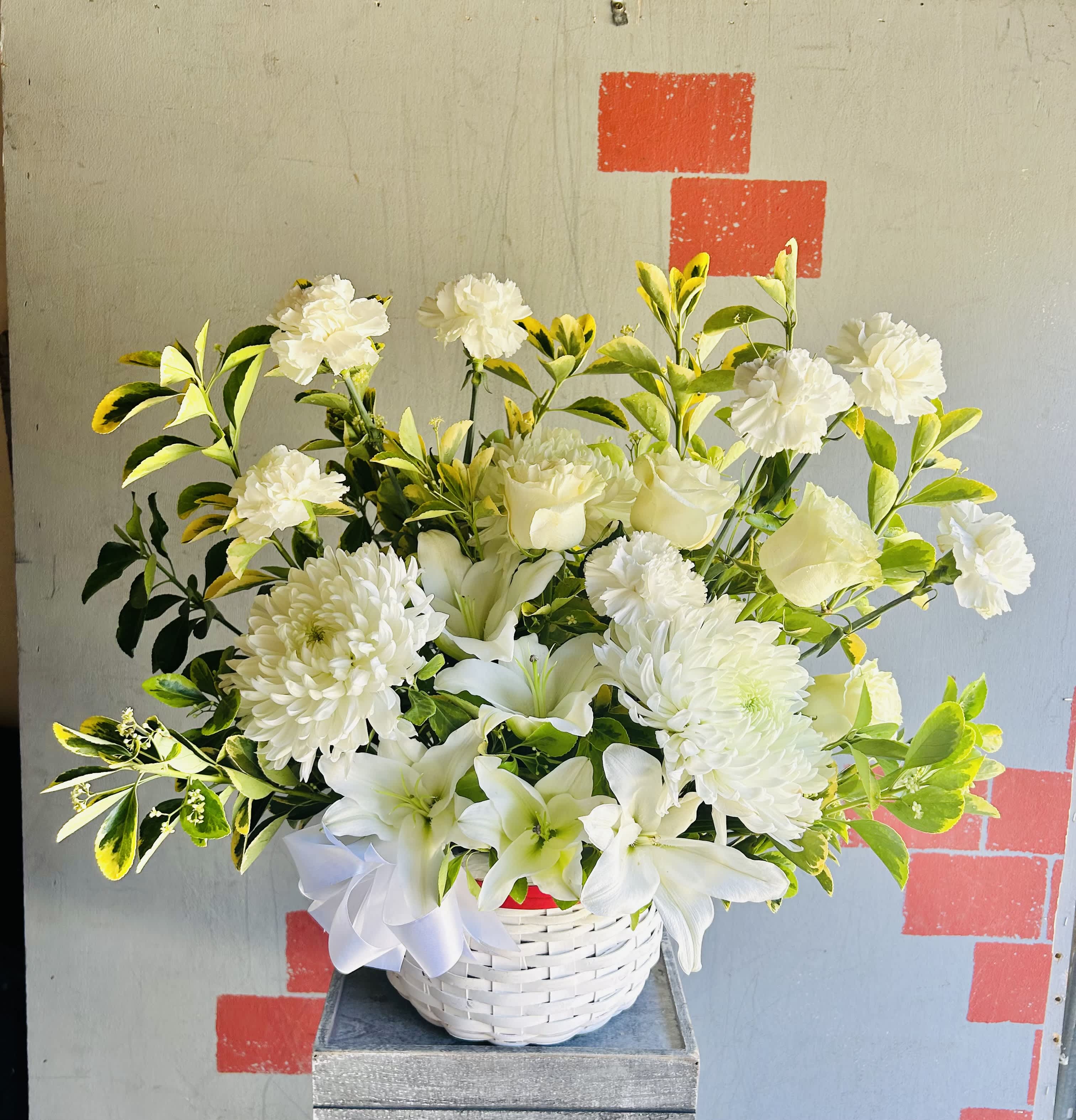 White Enchantment - White basket arrangement featuring lilies, chrysanthemums, roses, carnations, and green accents