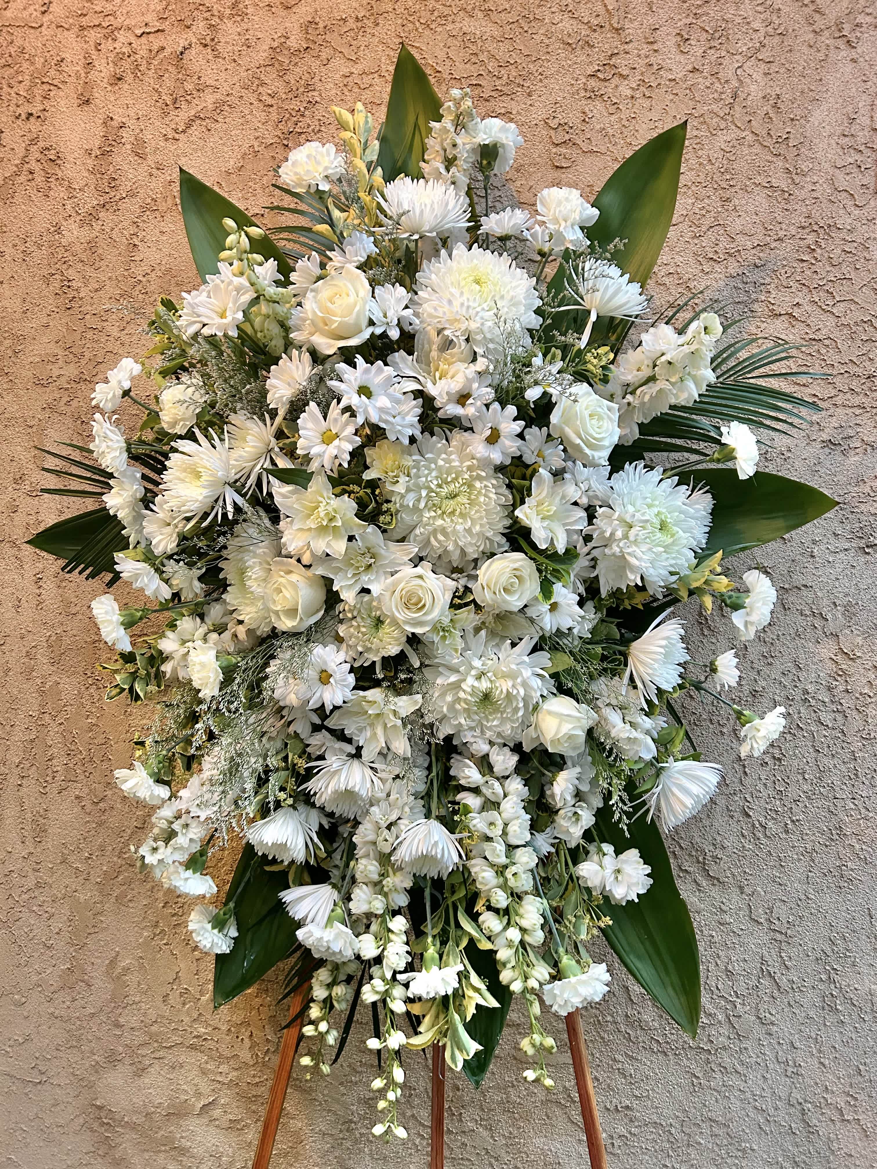 Our Haven - Beautiful spray arrangement featuring white roses, lilies, chrsanthemums, delphinium, daisies, and green accents