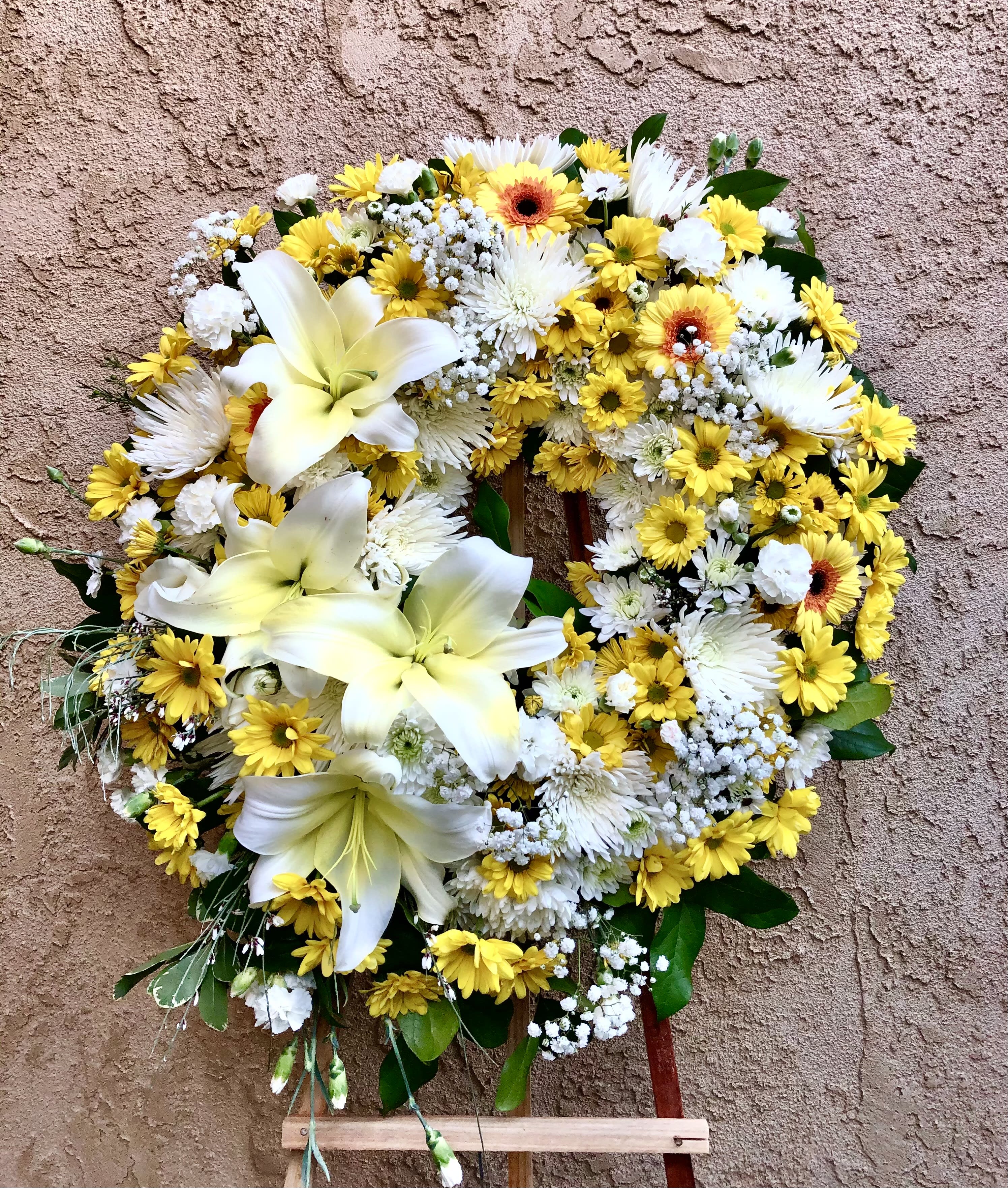 Glimpse of Sunshine - Beautiful standing spray arrangement featuring lilies, daisies, mums, baby breathes, carnations, and green leaf accents 
