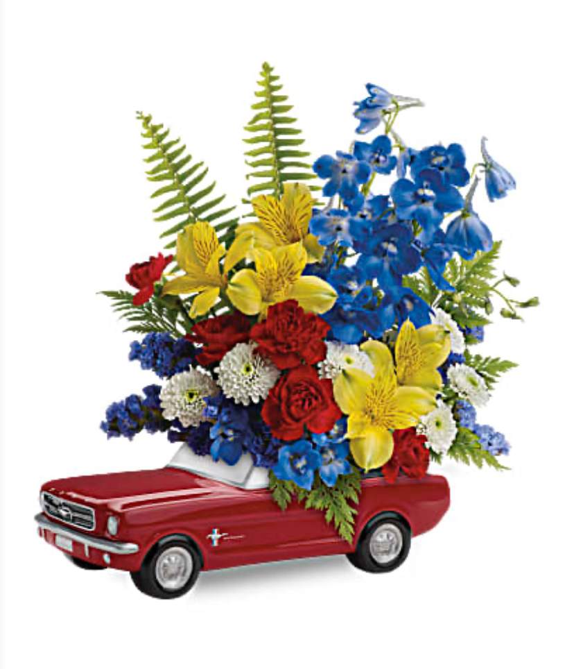 '65 Ford Mustang Bouquet '65 Ford Mustang Bouquet - Celebrate his special day with a true classic! This '65 Ford Mustang in classic poppy red with a bold bouquet is a one-of-a-kind collectible gift he'll always treasure. This bright bouquet features yellow alstroemeria, red miniature carnations, white button spray chrysanthemums, blue delphinium, blue sinuata statice, leatherleaf fern and sword fern. Delivered in Teleflora's exclusive '65 Ford Mustang collectible keepsake.