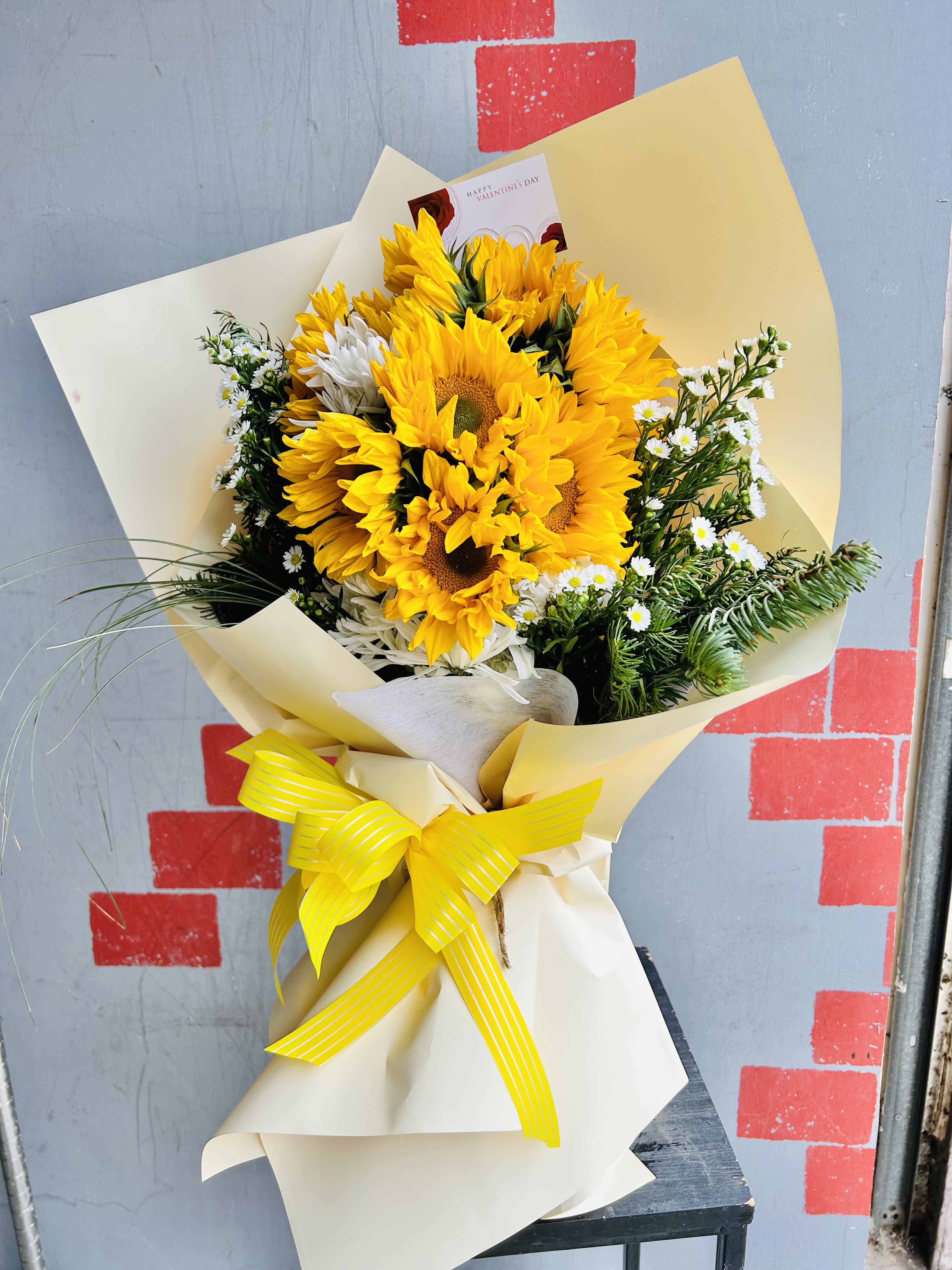 Soaring - Beautiful yellow bouquet of sunflowers and green accents.