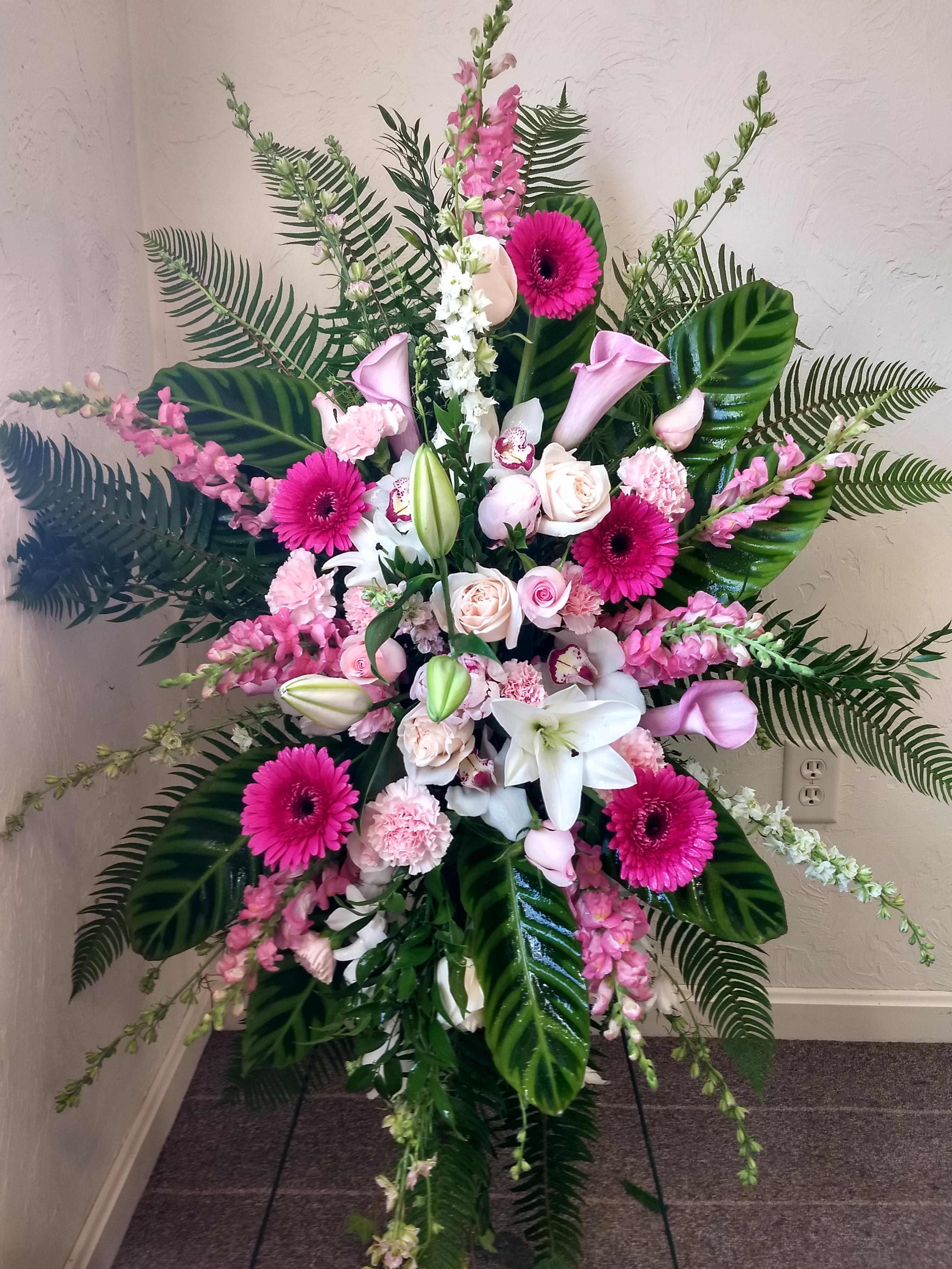 Glorious Pastel Farewell Spray Glorious Pastel Farewell Spray - Glorify a life well-lived with this magnificent spray of pink hydrangea, roses and lilies--a radiant, reflective celebration of her beauty and love. This glorious spray includes Lilies, Orchids, Gebera, calla liliyes, roses, spray roses, carnations, pink larkspur, pink snapdragons, pink stock, huckleberry, sword fern and greenery and more. **** Please note: 48 hour notice MAYBE REQUIRED We custom-design this arrangement using best-of-day seasonal flowers. This image is a general representation of its size and style and may not feature the exact flowers shown. Due to disruptions in the global supply chain and staff shortages, we may have to make last minute substitutions to your selected design. If we need to make significant changes we will call you first to get your approval*** Thank you for understanding.