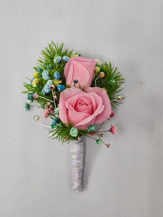 Candyland Boutonniere Candyland Boutonniere - Select this boutonniere featuring pink spray roses and rainbow babies breath with accents of pink iridescent rhinestones wrapped in pink ribbon. Each boutonniere comes with two metal pins to pin on a jacket lapel or shirt. Exact ribbon may vary