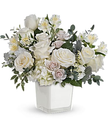 Teleflora's Peaceful Clouds Bouquet Teleflora's Peaceful Clouds Bouquet - As serene as soft white clouds floating in a crisp blue sky, this elegant white rose bouquet in a simple glass cube brings peace and beauty to any occasion