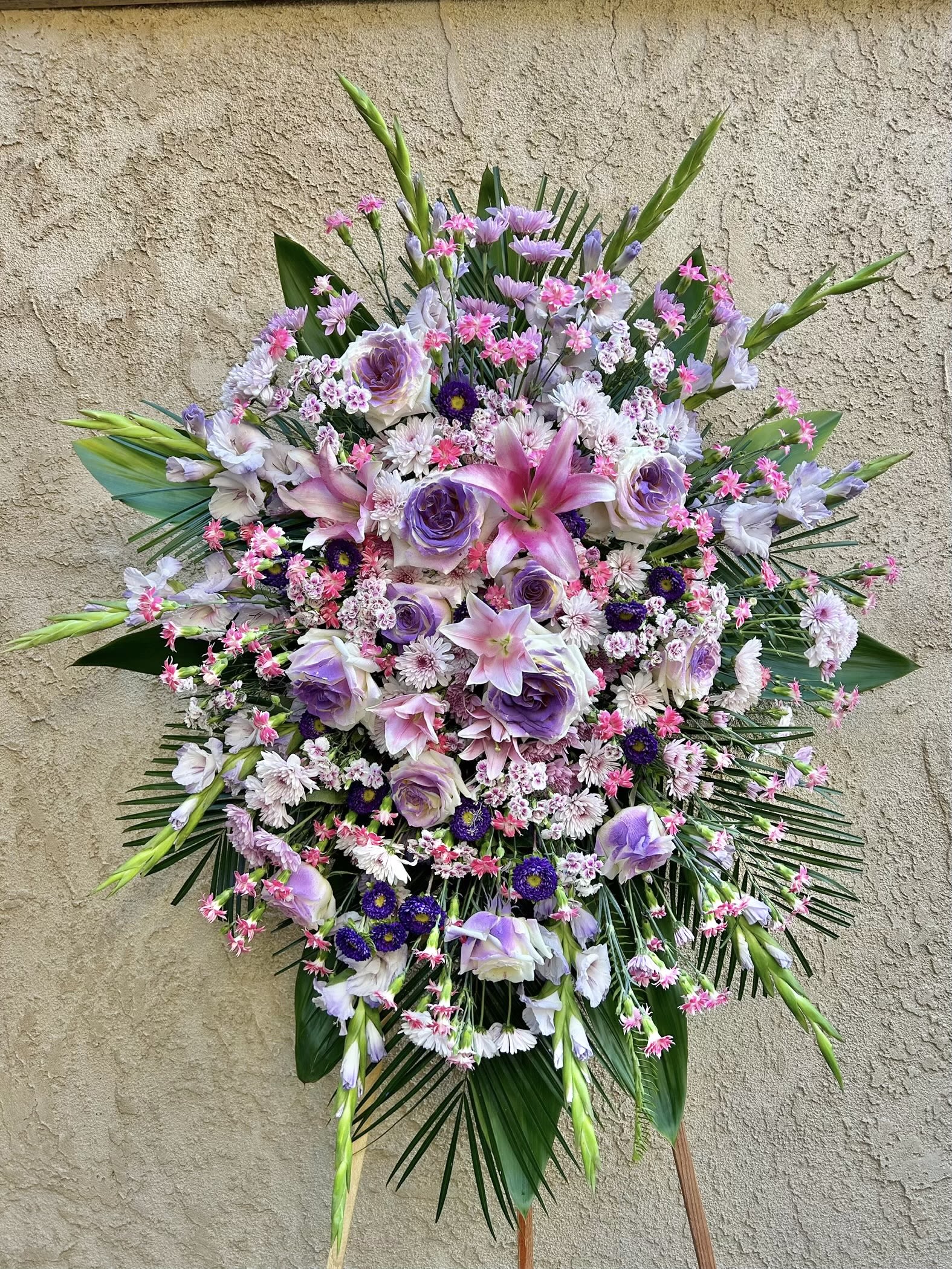 Gentle Grace - Beautiful spray arrangement featuring chrysanthemums, daises, lilies, gladiolus, carnations, zinnia, and green accents