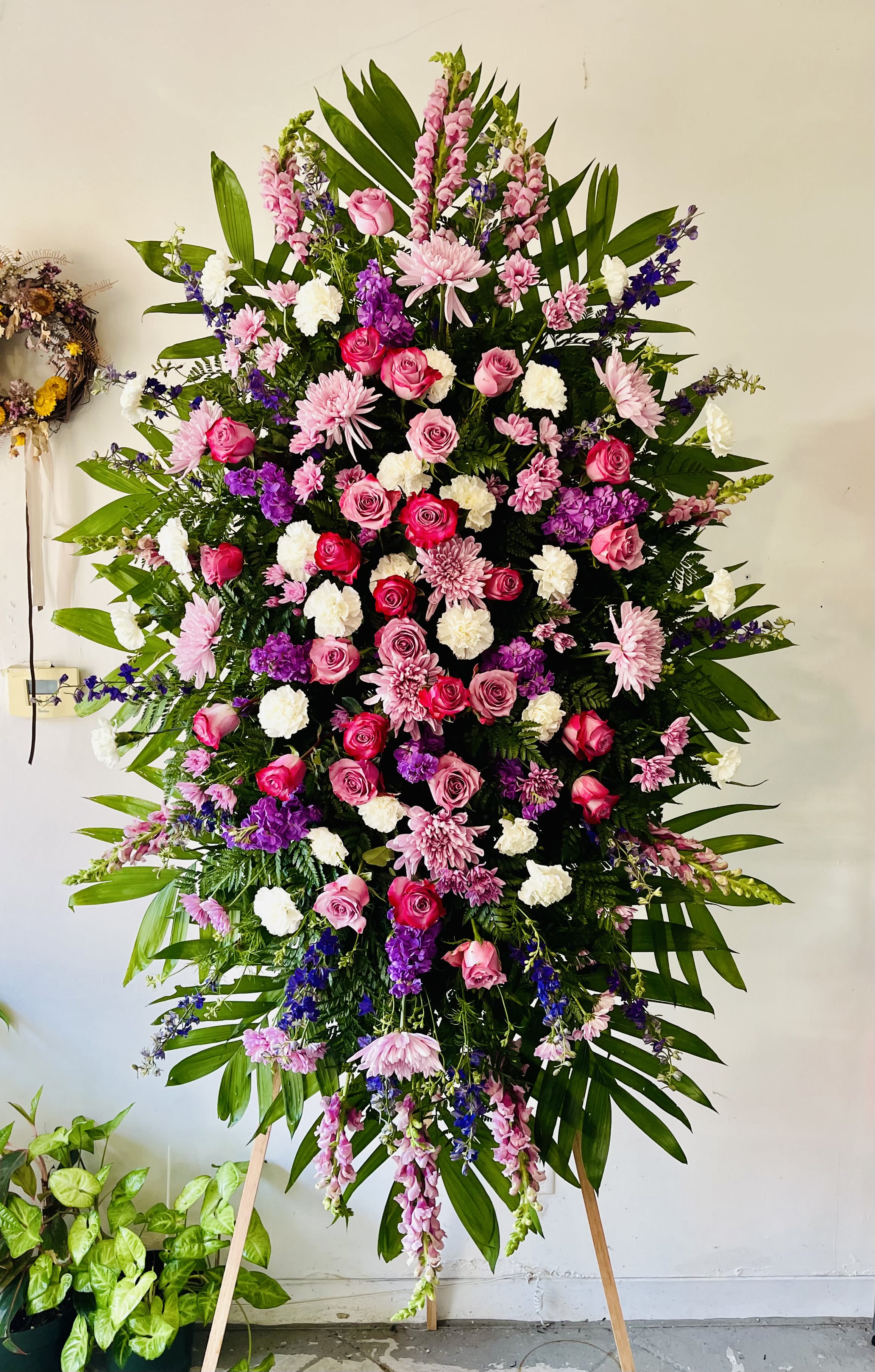 Elegant Tribute - Lavender Elegant Tribute - Lavender - The Elegant Tribute - Lavender Spray is an exquisite display of sweet serenity. Lavender roses, chrysanthemums, carnations and more are artfully arranged amongst emerald palm fronds and lush greens. This standing spray is an excellent way to honor the life of your loved one. Optional Banner included upon request. Include your banner message in the Florist Instructions during checkout, or give us a call at (562)692-0438.