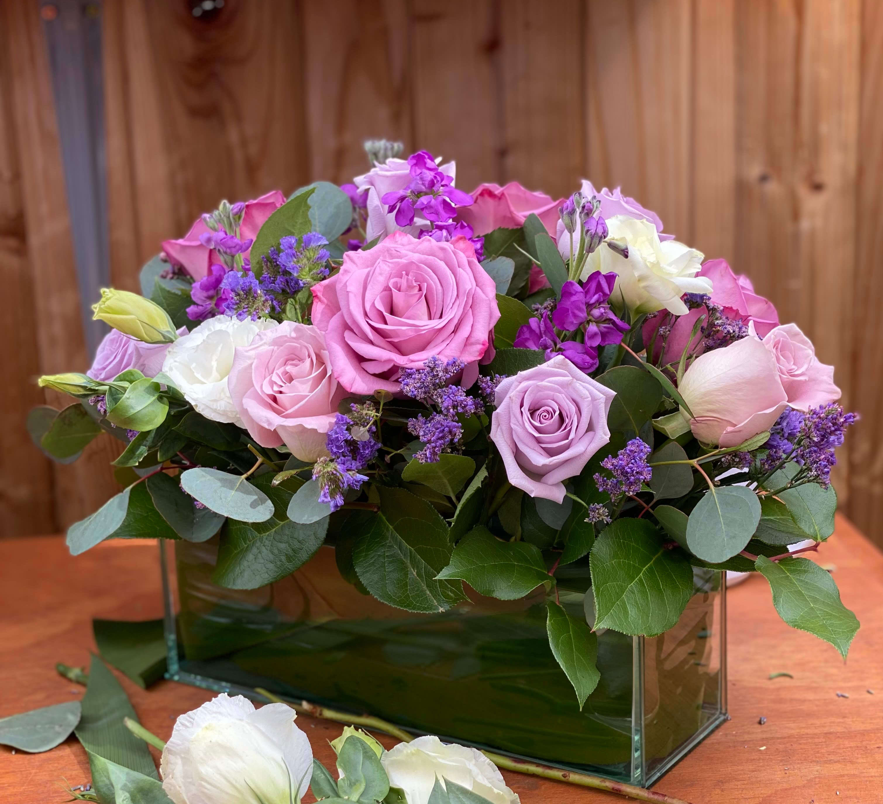Lavender Haze - For all the purple lovers!...All fresh purple roses with touches of white fresh blooms. Arranged in a glass vase 