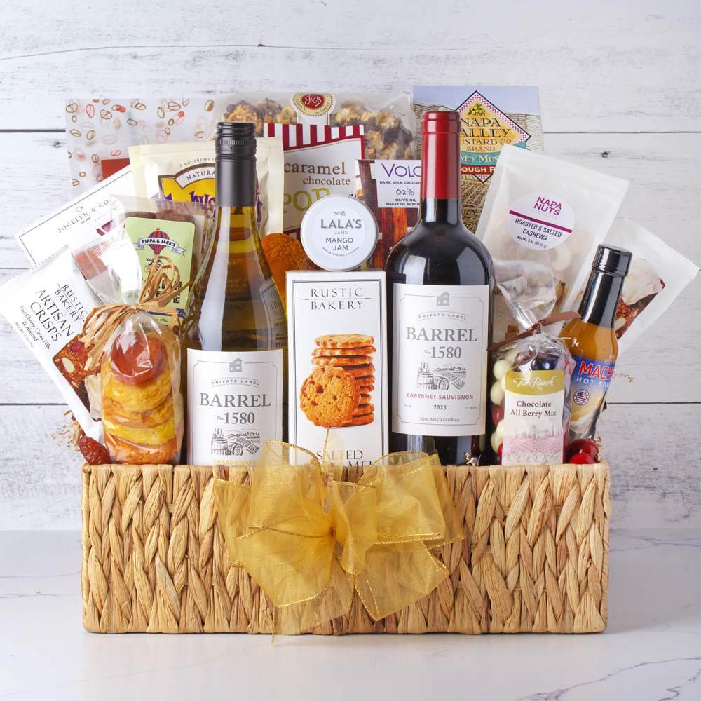 Ultimate Wine & Gourmet Feast Gift Basket Ultimate Wine & Gourmet Feast Gift Basket - Unveil a world of indulgence with this luxurious collection featuring a bottle of rich red wine and a bottle of crisp white wine, perfectly paired with an array of gourmet delights. Savor the flavors of artisanal cheese, savory salami, decadent chocolate, sweet jam, crispy crackers, popcorn, crunchy nuts, and delightful cookies. Ideal for any celebration or special occasion, this basket promises a memorable experience of elegance and taste for the discerning connoisseur. Contents: Caramel chocolate POPcorn, Jocelyn & Co Camembert Cheese Spread, .7 oz Artisan Crips, Cold brew+ cocoa nib apple cider caramel treats, Mashuga Nuts Cinnamon and Spice, Mango Jam, Dried Apricots, Barrell 1580 Chardanay, Barrell 1580 Cabernet Sauvignon, Salted Caramel Shortbread, Chocolate All Berry Mix, 3 oz Roasted and Salted Cashews, Mach 1 Hot Sauce 5oz and Honey Mustard Sourdough Nuggets.