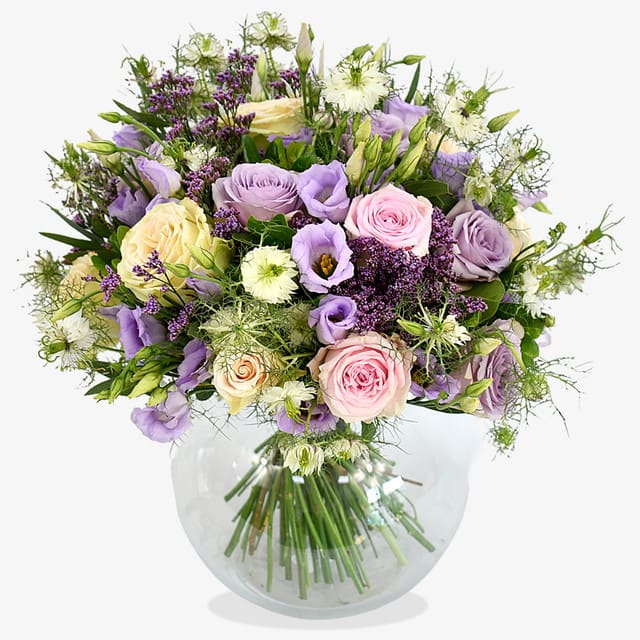 Lilac Charm Bouquet Lilac Charm Bouquet - A magical, pastel palette encapsulates this charming design; with roses and lisianthus taking pride of place. Rich purple limonium is accentuated by white nigella in a whimsical floral display. Finished with seasonal greenery, this bouquet will enliven anyone's home.