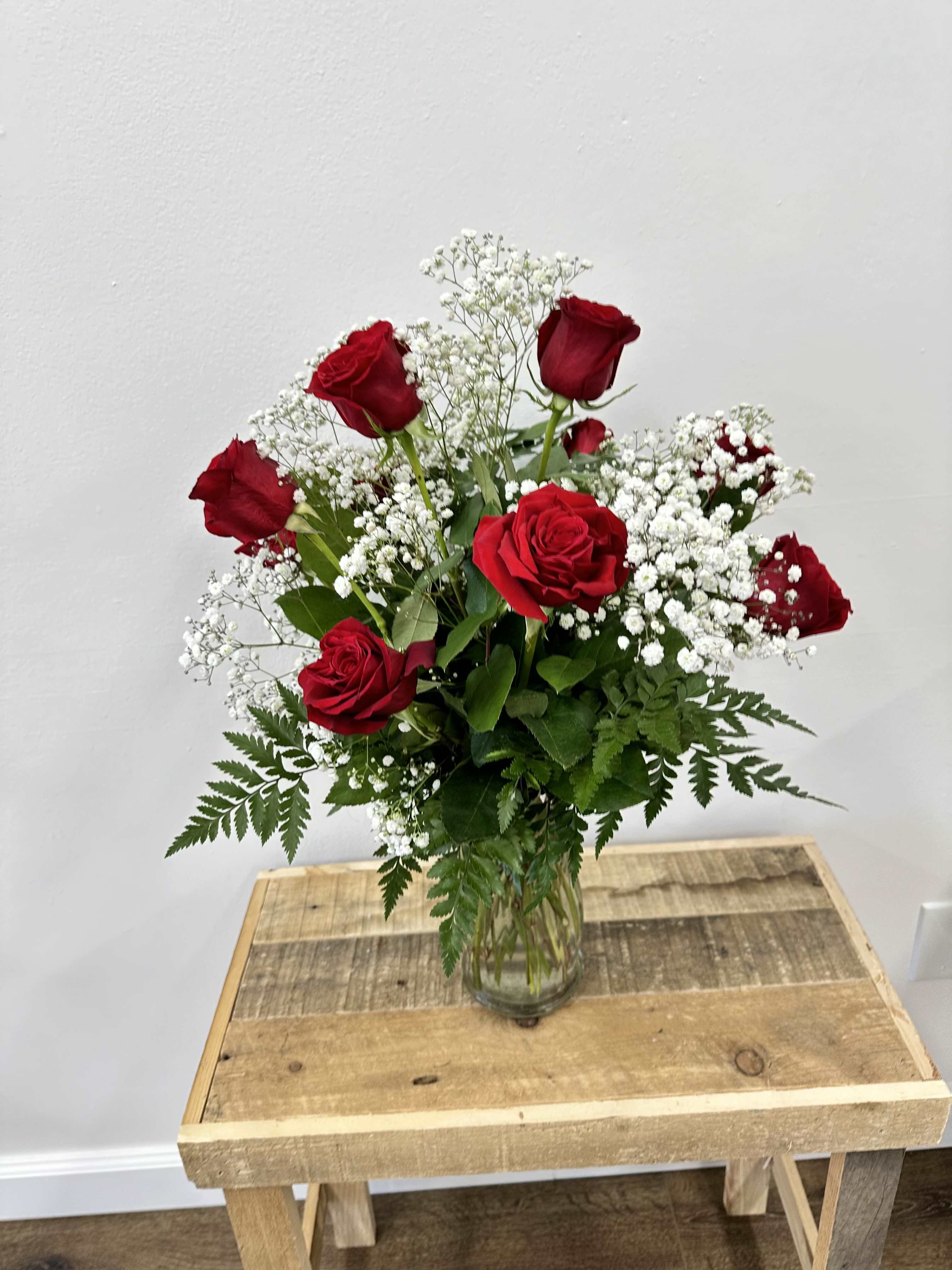 Timeless Grace Timeless Grace - This stunning bouquet features a dozen premium red roses, complemented by delicate baby's breath and lush greenery, all elegantly displayed in a tall, clear glass vase. Perfect for romantic gestures, special occasions, or simply to add a touch of elegance to your home, this arrangement exudes sophistication and charm.