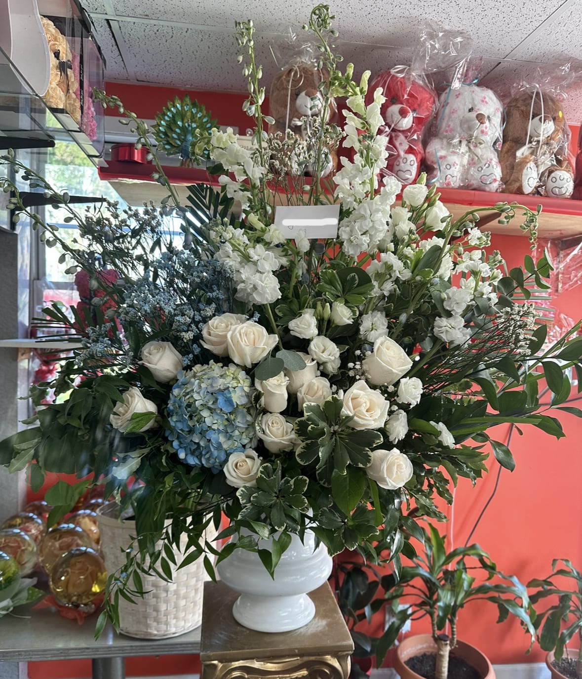 Blue and White Basket - Honor your loved one with this elegant basket containing elegant flowers such as white delphiniums and blue hydrangeas. 