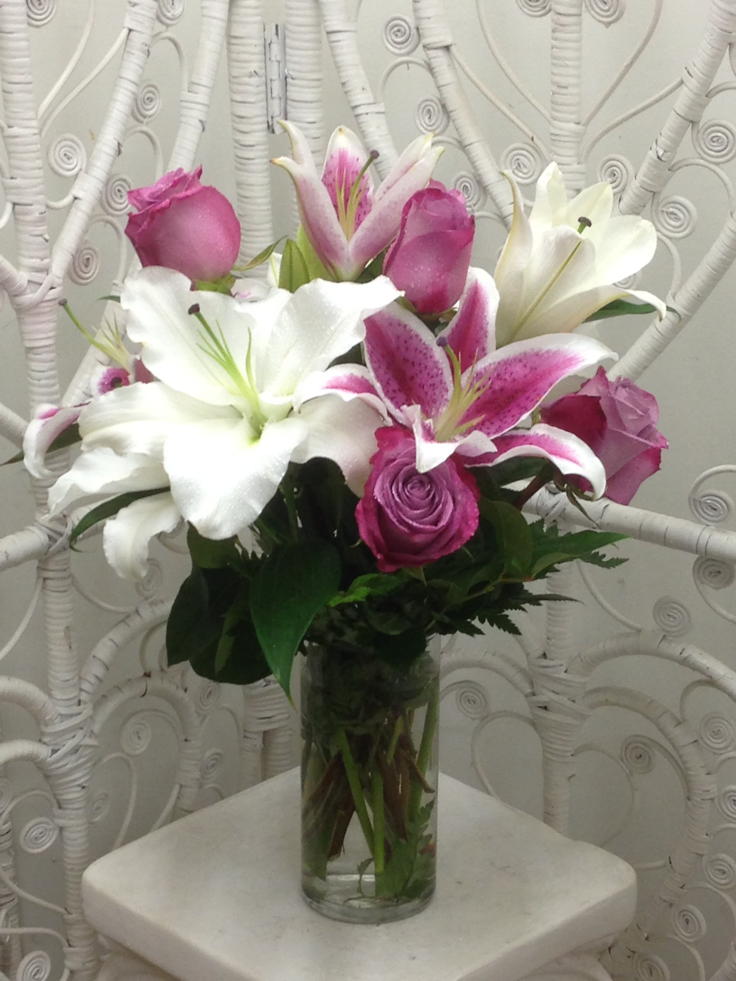 Sweet Lavender Roses and Lovely Lilies Sweet Lavender Roses and Lovely Lilies - Beautiful, fragrant lilies and lovely lavender roses combine for an expressive, classic look arranged with lush greens in a clear glass vase.