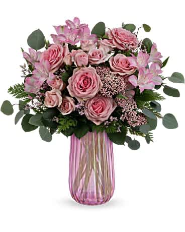Teleflora's Rosy Iridescence Bouquet - Mom is sure to &quot;pink&quot; up when this pink rose bouquet arrives, beautifully arranged in an iridescent pink glass keepsake vase. Pink roses, pink spray roses, pink alstroemeria and pink rice flower are arranged with leatherleaf fern, pink limonium and silver dollar eucalyptus. Delivered in an Iridescent Delight vase.