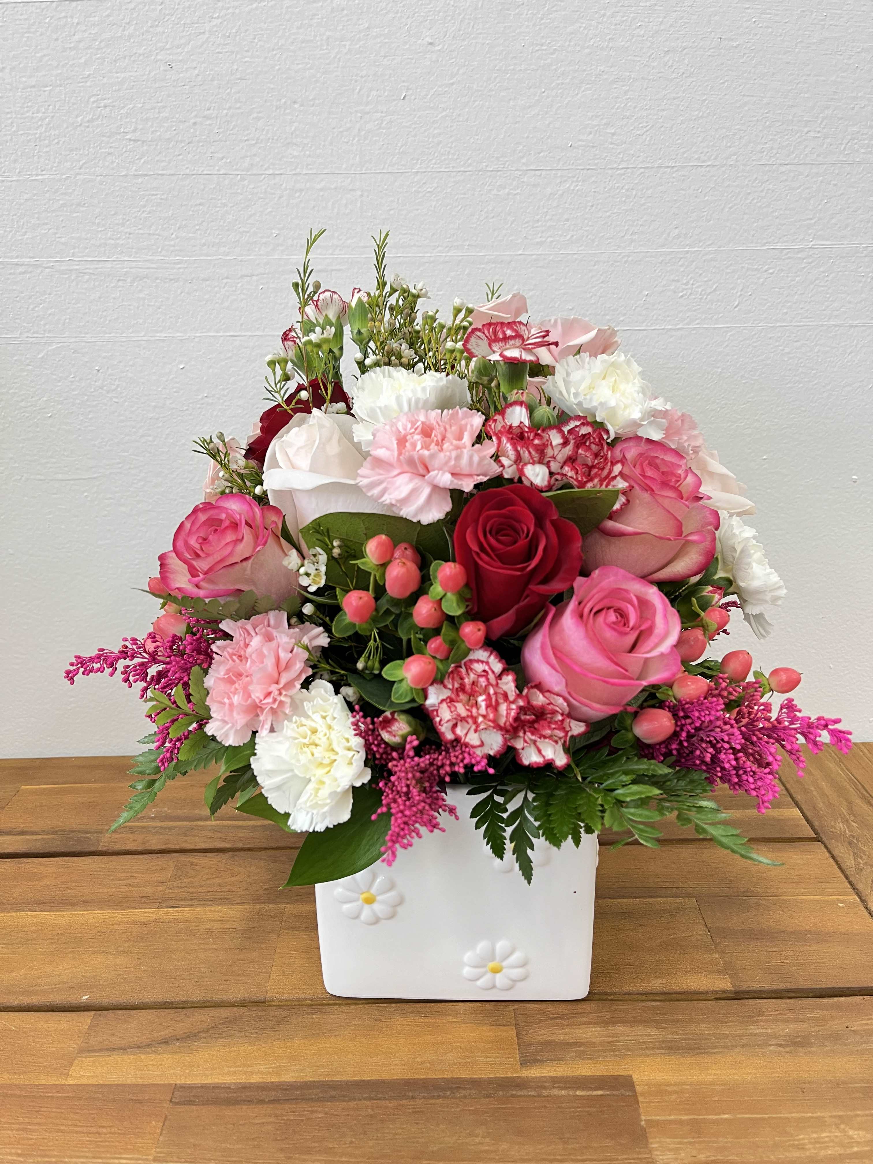 Square of Blossoms  - &quot;Square of Blossoms&quot; features a white vase filled with light pink, white, and red roses, complemented by pink and white carnations and mixed greenery.