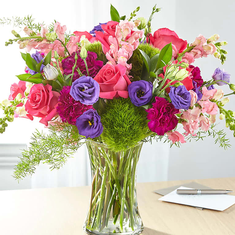 Lila Bouquet - Roses and snapdragons add gorgeous texture to complement the blooms in this arrangement. All Occasion Glass Pot Place your Order Online Monday to Saturday before 1:00 p.m. (E.T.) for same-day delivery.  “Orders received after hours will be delivered the next business day”. Check our coverage area. Occasionally, substitutions of flowers and/or containers happen due to weather, seasonality, and market conditions which may affect availability. If this is the case with the gift you’ve selected, we will ensure that the style, theme, and color scheme of your arrangement are preserved and will only substitute items of equal value or higher value.  CARE INSTRUCTIONS	 Keep the flower arrangement hydrated with natural water and change the water every two days. Do not spray any cleaning product on the flower arrangement. Do not place heavy objects directly on the flower arrangement. Keep flower arrangements out of direct sunlight and extreme heat. 