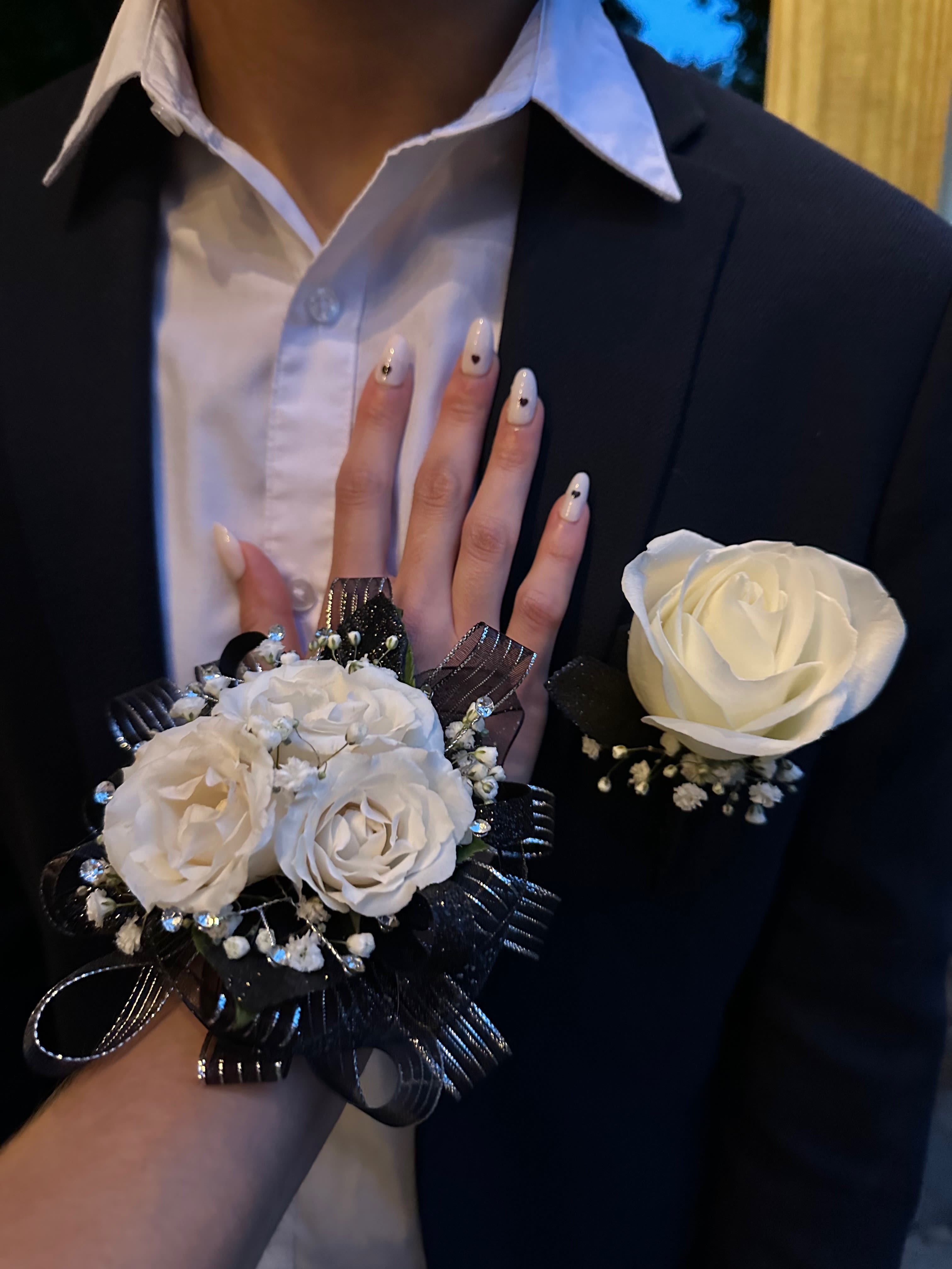 Corsage Set Corsage Set - Our corsage and boutonniere set is the perfect pairing for any special occasion. Expertly crafted to complement each other, this set features a beautifully designed corsage and a matching boutonniere, creating a harmonious look for couples. Choose from a selection of fresh, premium flowers and coordinating accents to suit your style and color palette. Whether for prom, a wedding, or another celebration, this set adds an elegant and cohesive touch to your attire, ensuring you and your partner look perfectly matched.