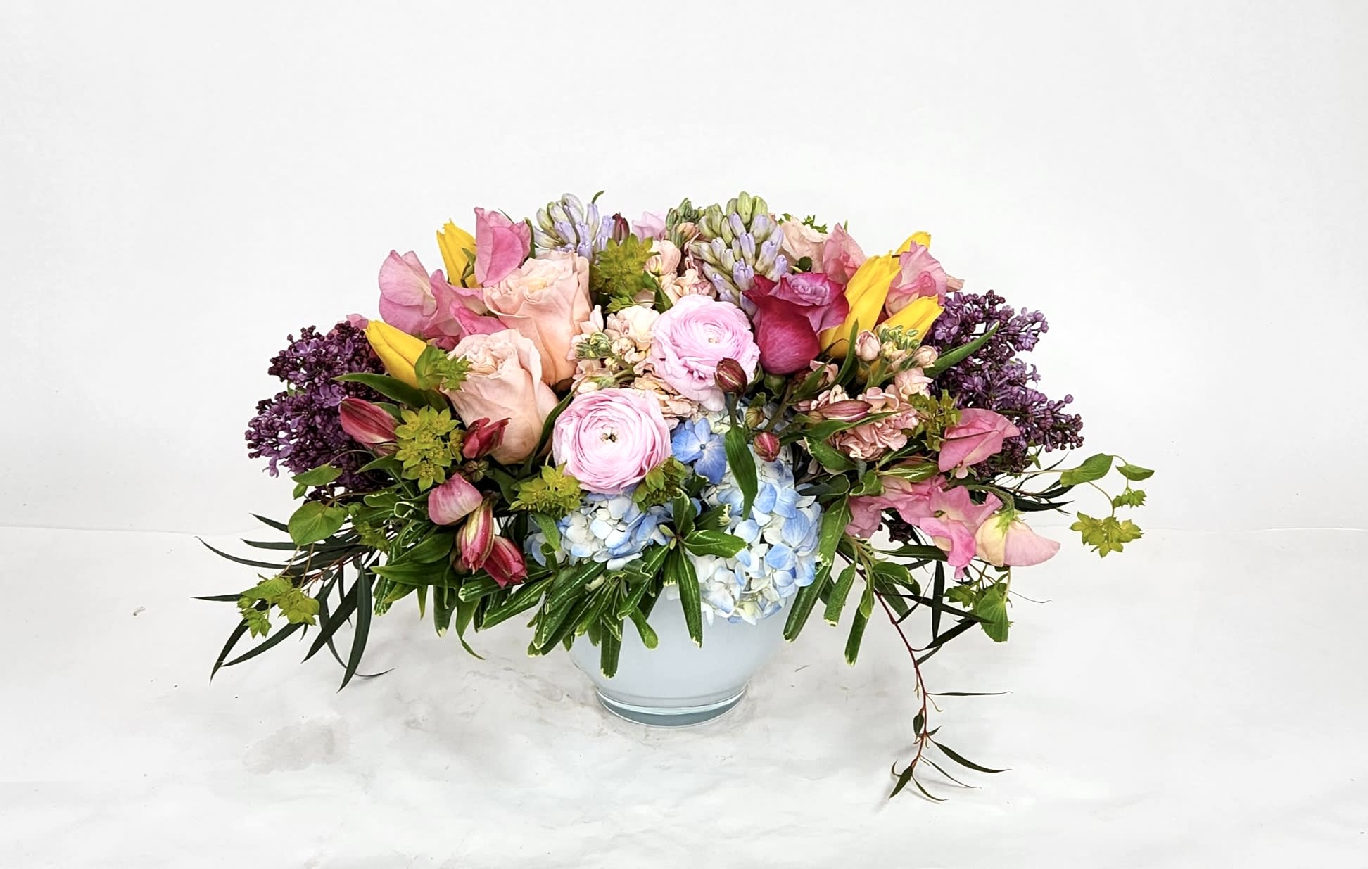 WILD ON THE FARM - A collection of Spring Flowers brought together in a pave of pastels and color.   a wonderful table piece and gift.  Hyacinth, Freesia, Roses, Sweet Pease, Lilac, etc..  (all flowers based on availability.) 