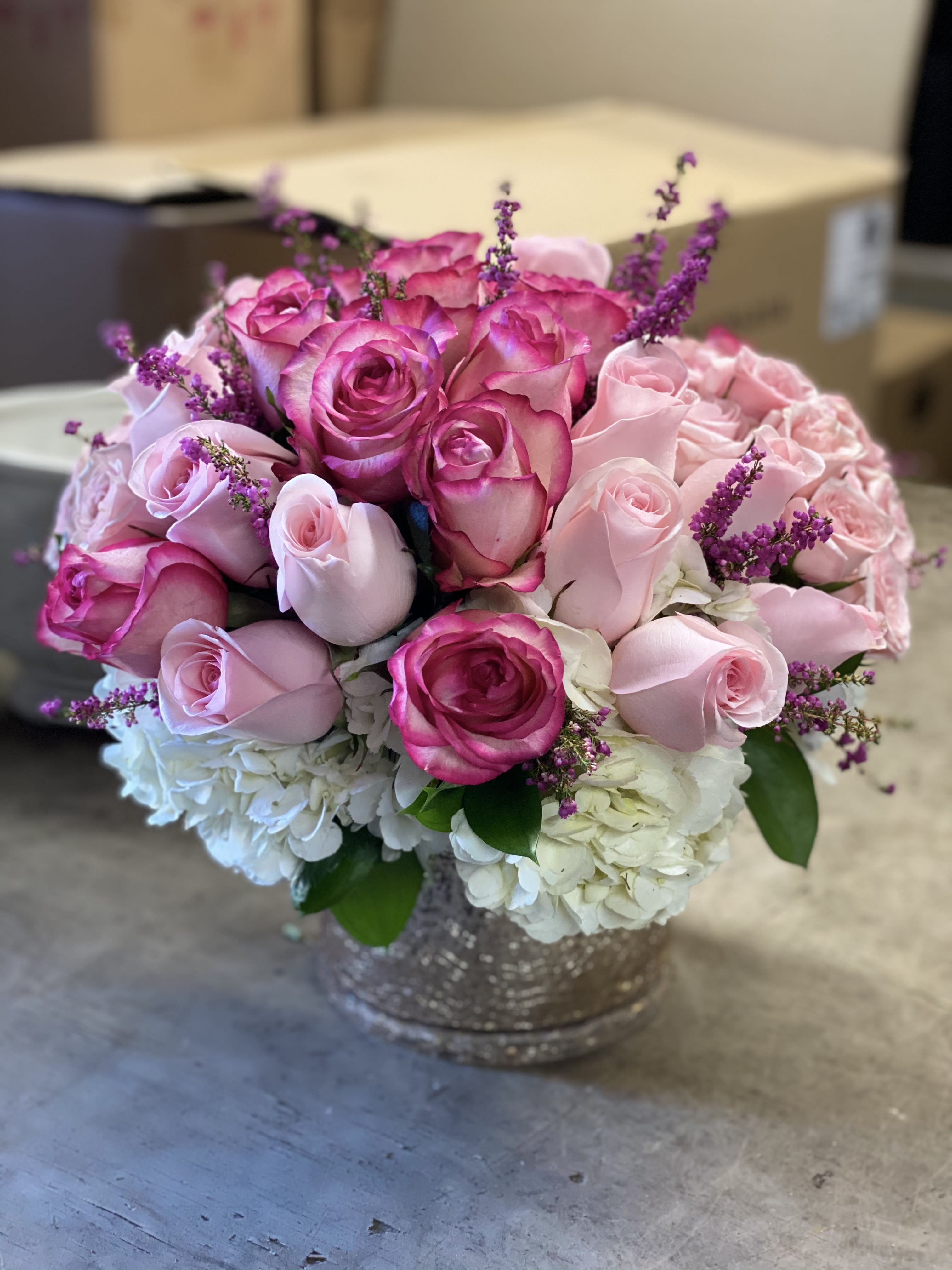 PINK LUSCIOUSNESS - Rose Gold Glass vase with Beautiful Ecuadorian Roses floating on a p[pillow of White Hydrangea, with floral accents..