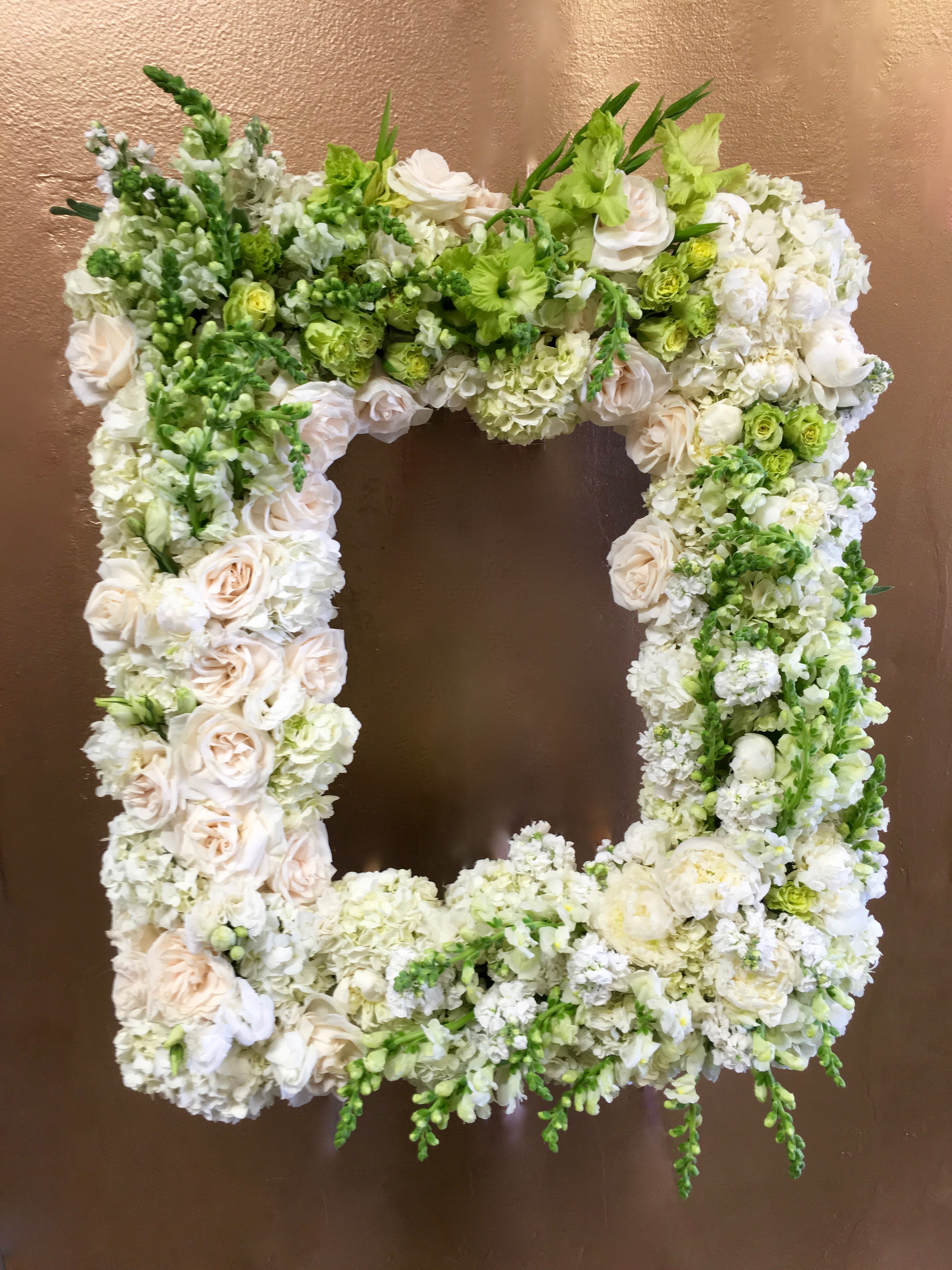 White and Green Rose Frame  - This frame includes white and green roses as well as matching snapdragons.     Dimensions of standard size frame are approximately 32x24  Large frame approximately 36x28. Frame is not included.    We include easel, printed banner, and delivery (some fees may apply). An additional banner can be added for $15.  