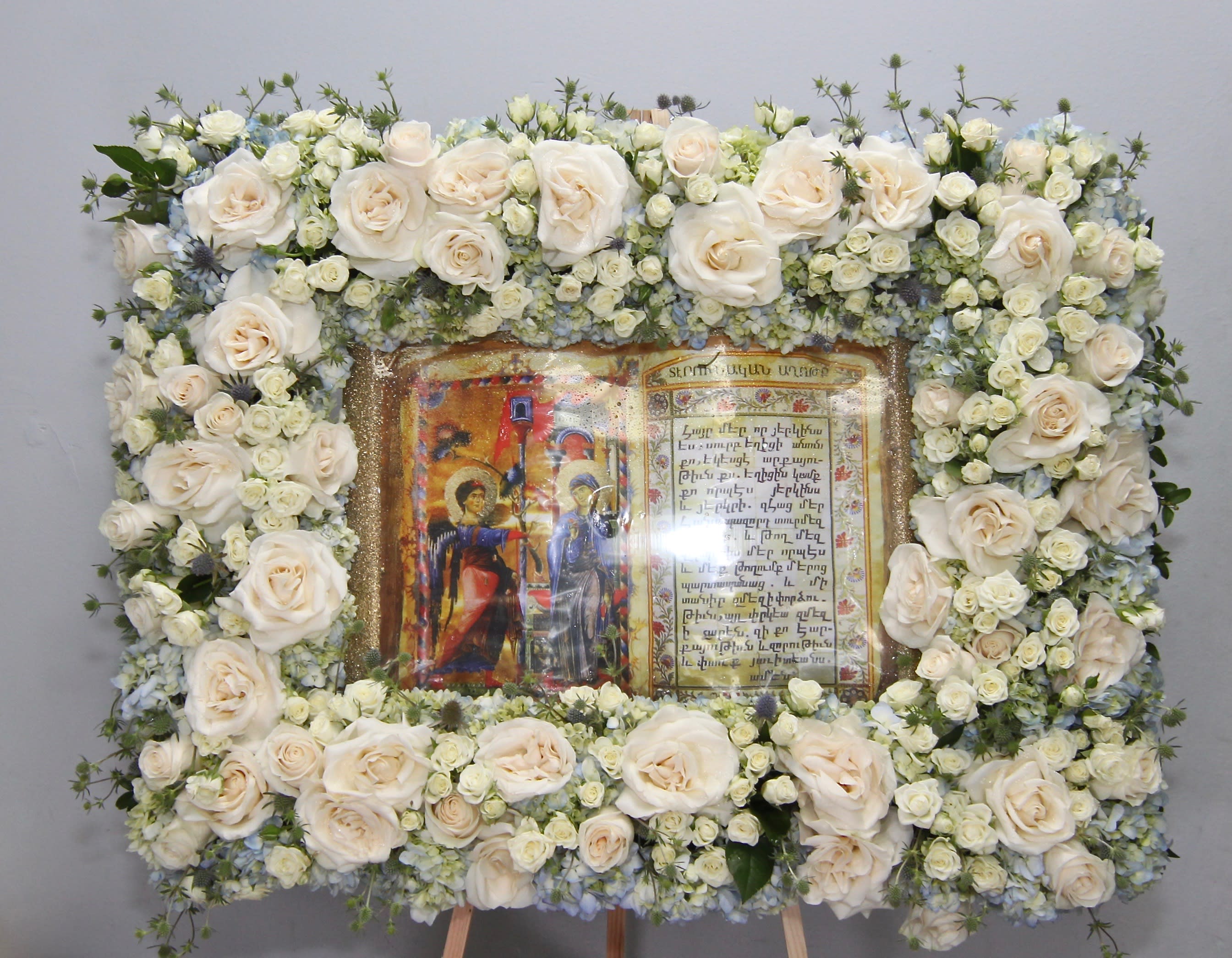 Roses and Hydrangea Bible  - With a subtle theme of blue, this frame arrangement includes roses, hydrangeas and seasonal florals.     Standard size is approximately 32x24. Large dimensions approximately 36x28.   