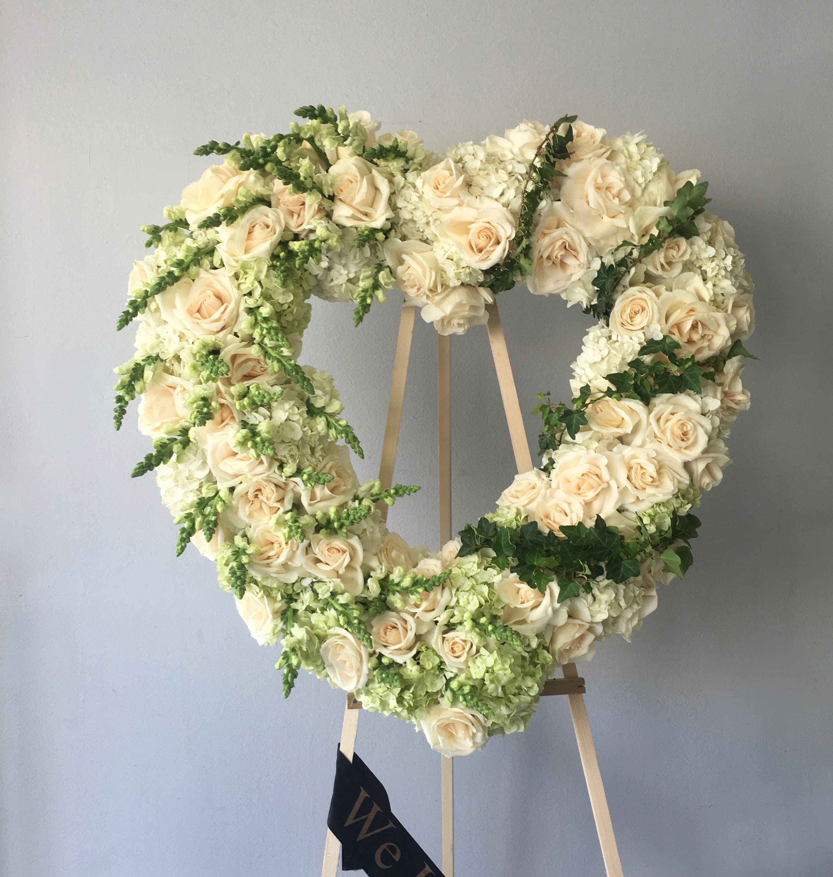 Striped with Green Heart  - This sympathy heart contains roses, hydrangeas, and seasonal greens, all arranged in an elegant striped pattern.     We include easel, printed banner and delivery (some fees may apply). An additional banner can be added for $15    Standard size is 30'', deluxe is 36'', and premium is 42''.