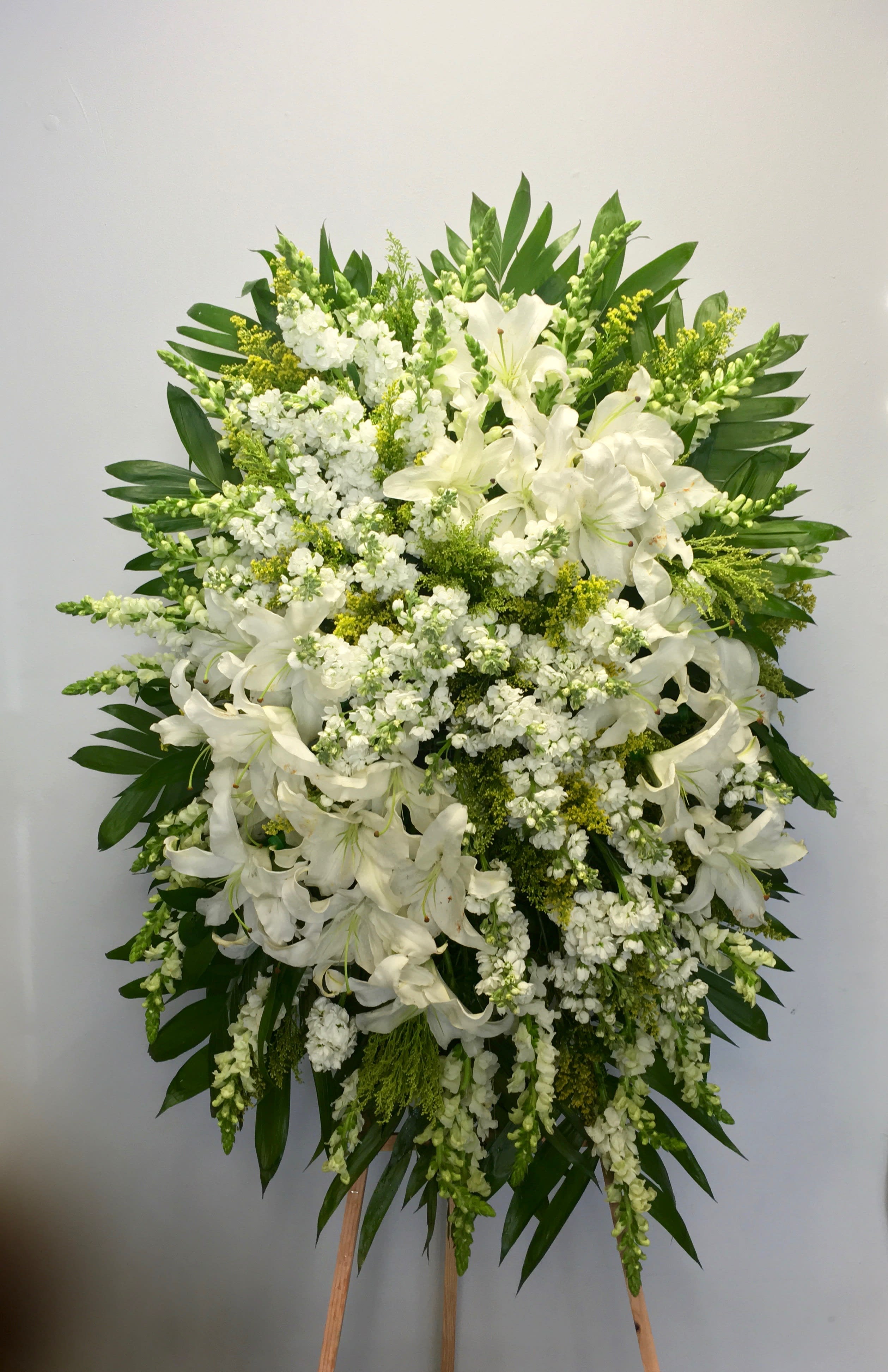 Lily Fields Spray  - This white spray includes stargazer lilies and fluffy florals to create a unique sympathy arrangement.     We include easel, printed banner and delivery (some fees may apply). An additional banner can be added for $15.    Standard size is 30'' wide, deluxe is 36'', and premium is 42''.